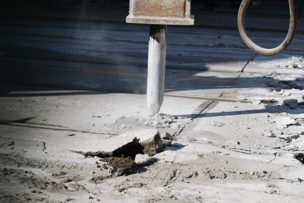 Jackhammer Breaking up Concrete on A Road Surface — Ultra Services Ground Pavement & Building in Forbes, NSW