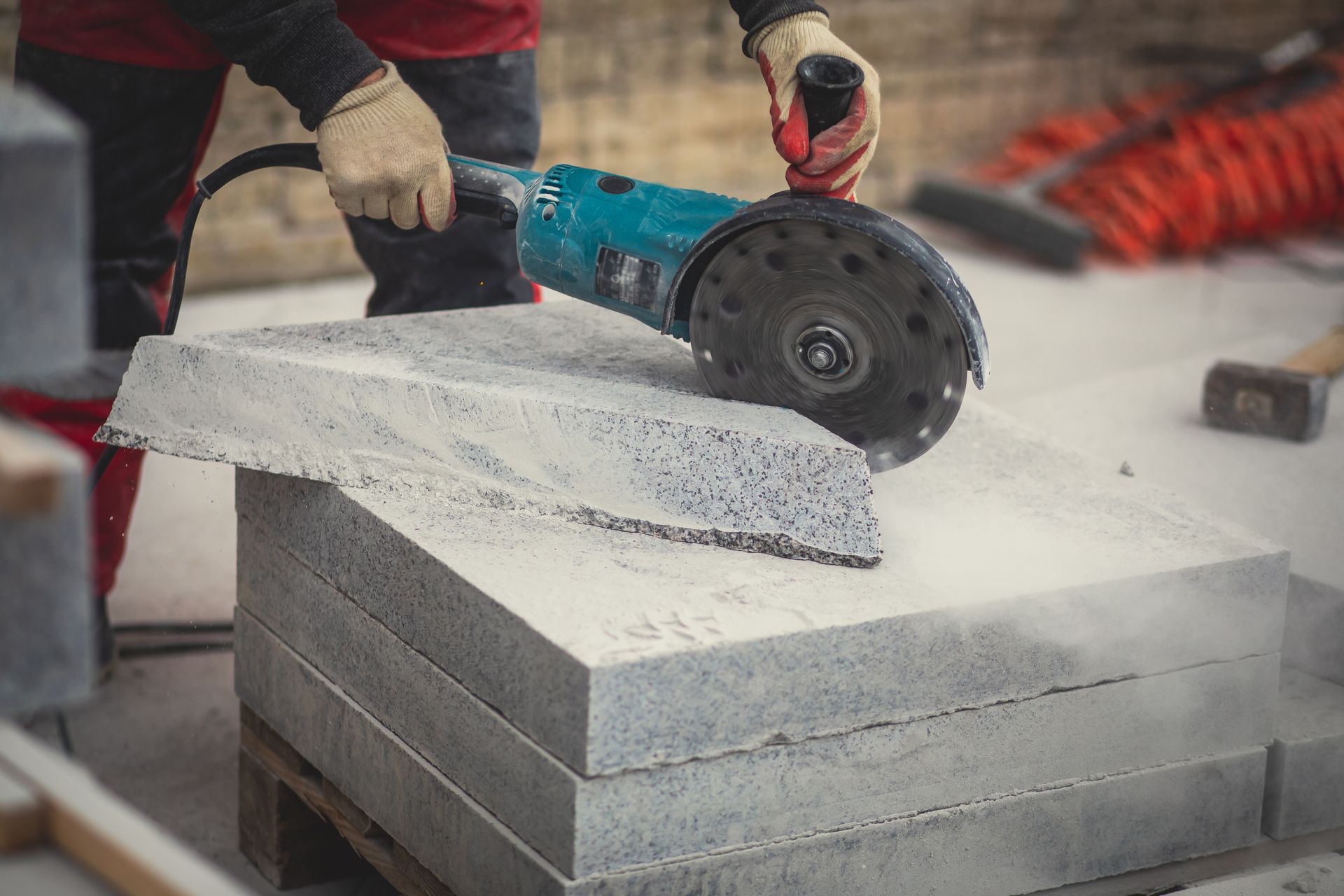 Person Cutting a Concrete Block with A Circular Saw Outdoors — Ultra Services Ground Pavement & Building in Forbes, NSW