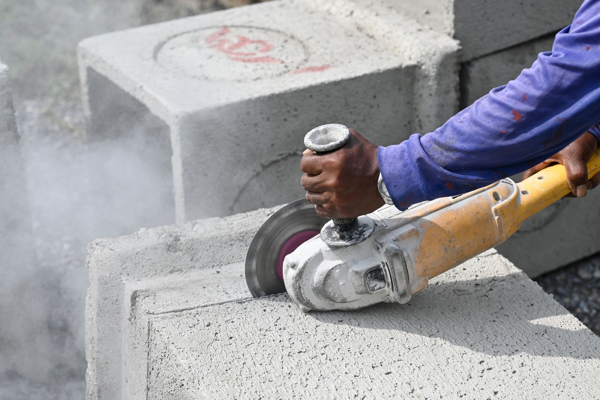 Person Using an Angle Grinder to Cut Concrete Blocks — Ultra Services Ground Pavement & Building in Bourke, NSW