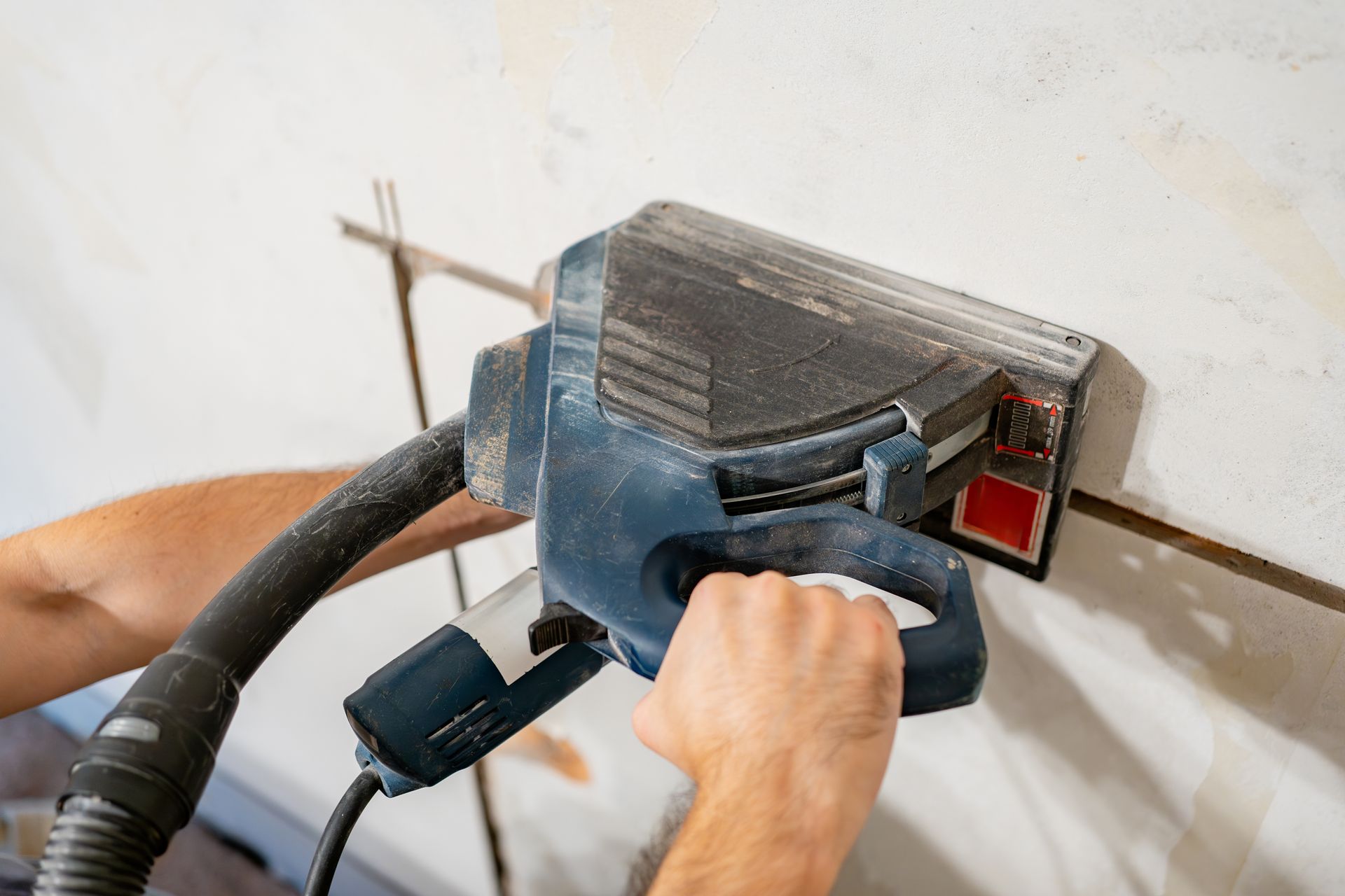 A Person Using a Concrete Saw to Cut Through a Wall — Ultra Services Ground Pavement & Building in Bourke, NSW