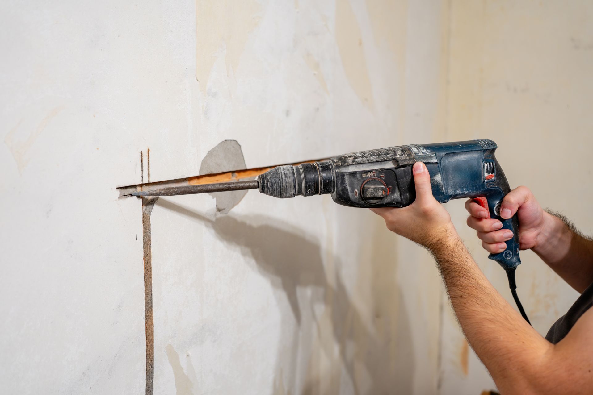 Person Using a Power Drill on A Wall to Create a Hole — Ultra Services Ground Pavement & Building in Mudgee, NSW