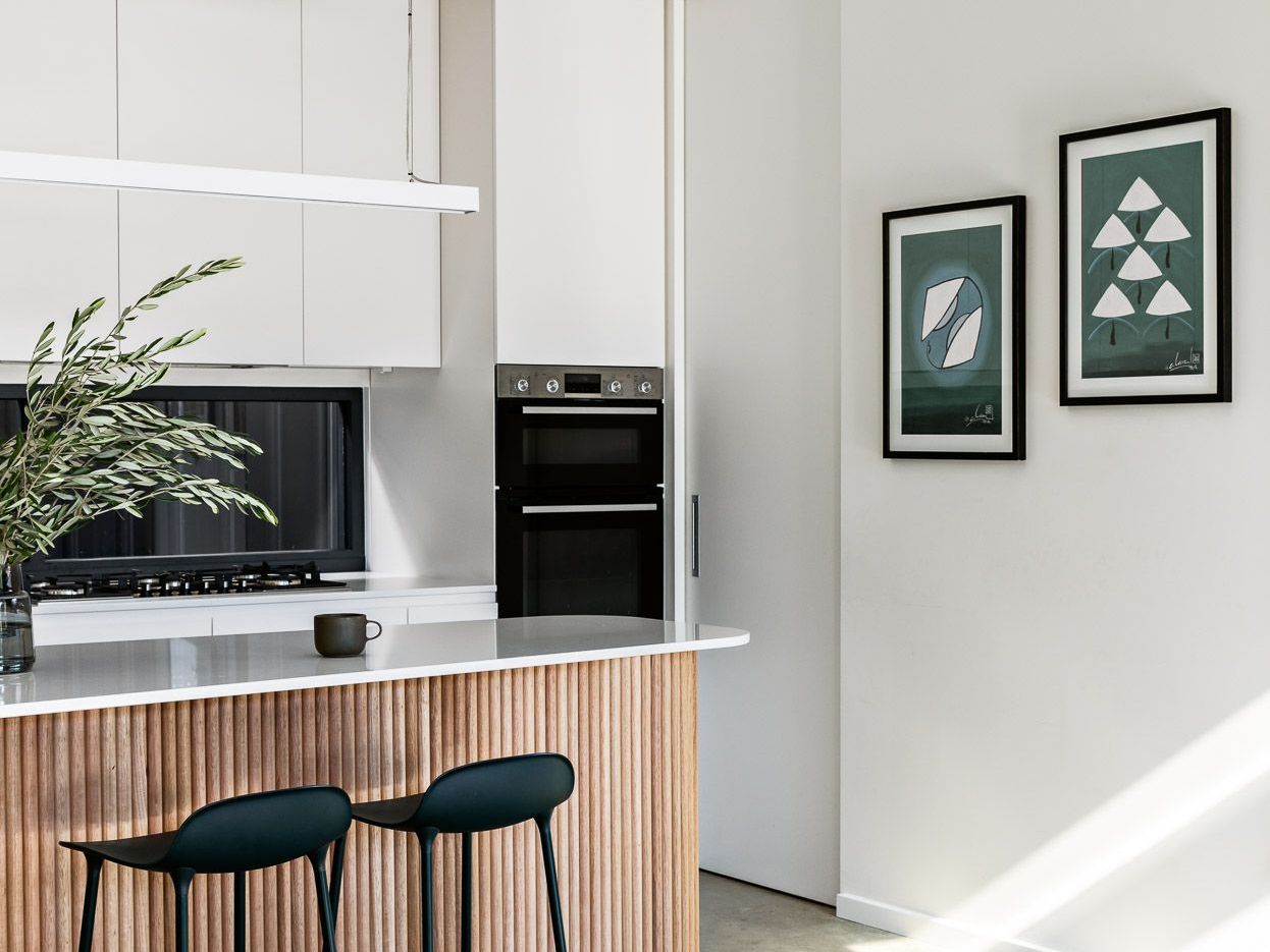A Kitchen With Stools And A Clock On The Wall — Concept Design Kitchens & Joinery In Forster, NSW