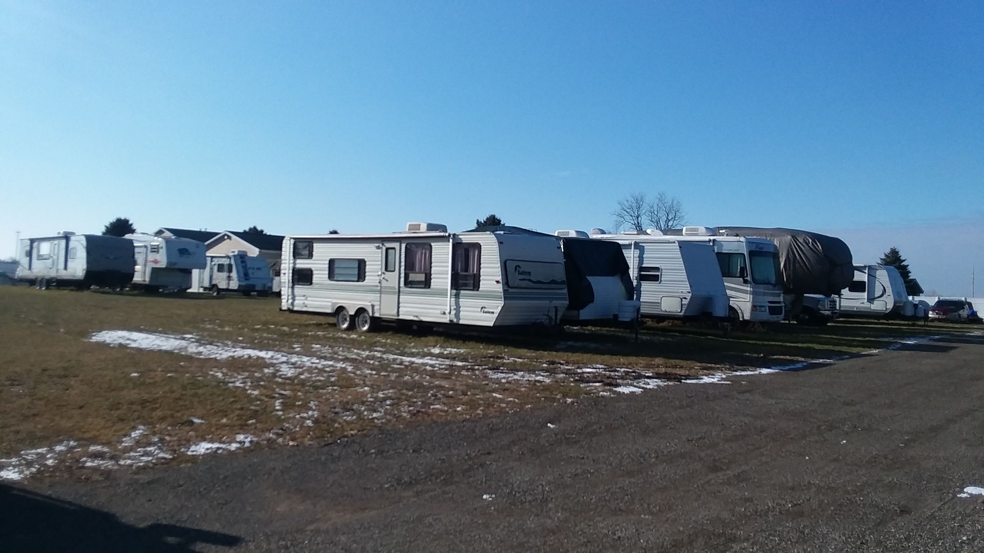 A row of rvs are parked on the side of the road.
