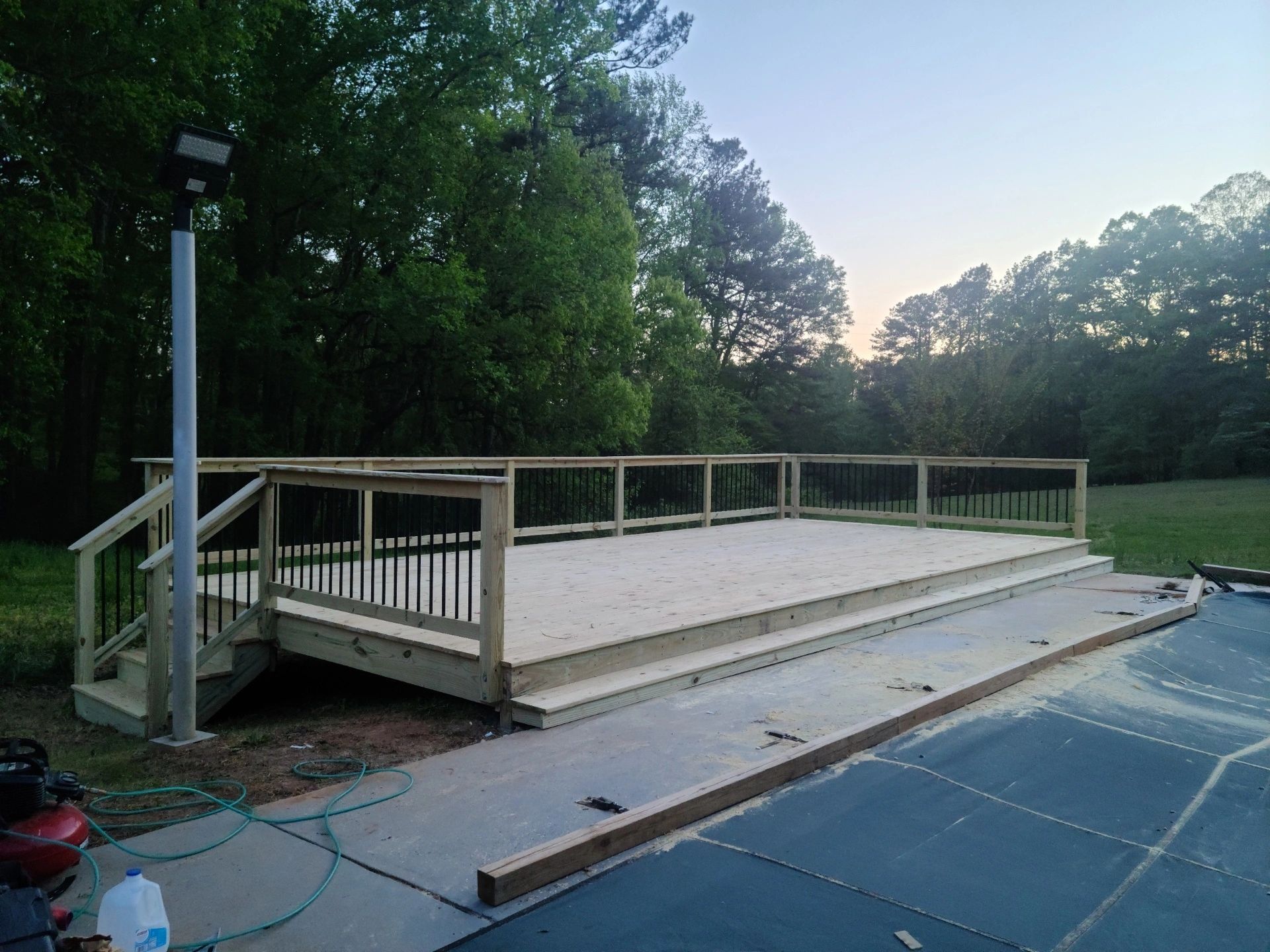 A wooden deck is being built next to a swimming pool.