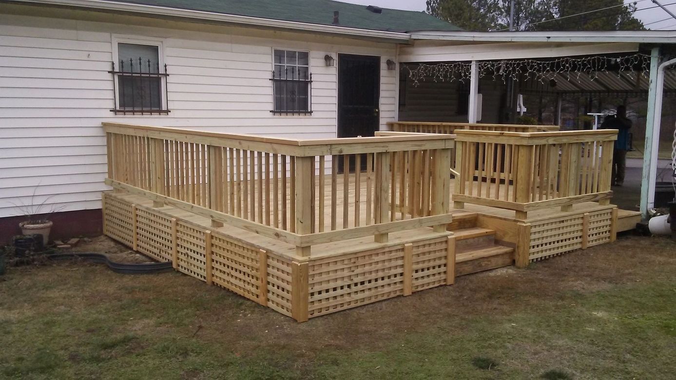 A white house with a wooden deck in front of it