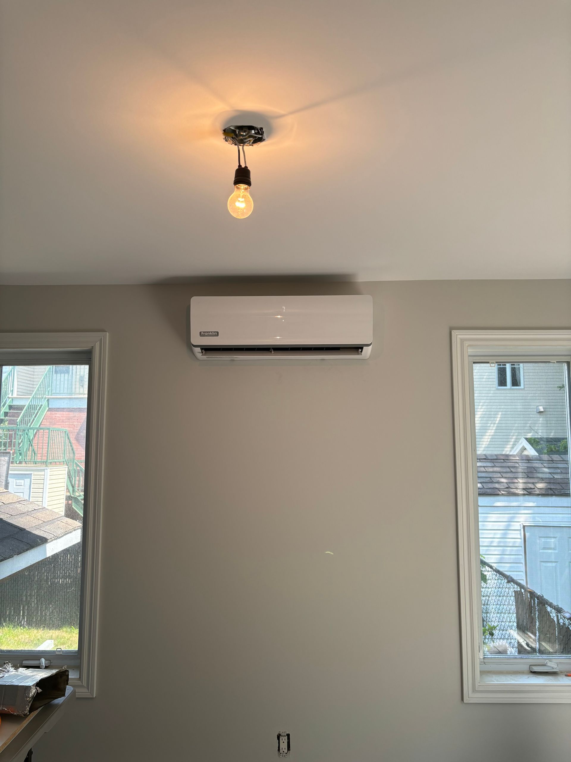 Une pièce avec une fenêtre et un ventilateur de plafond.