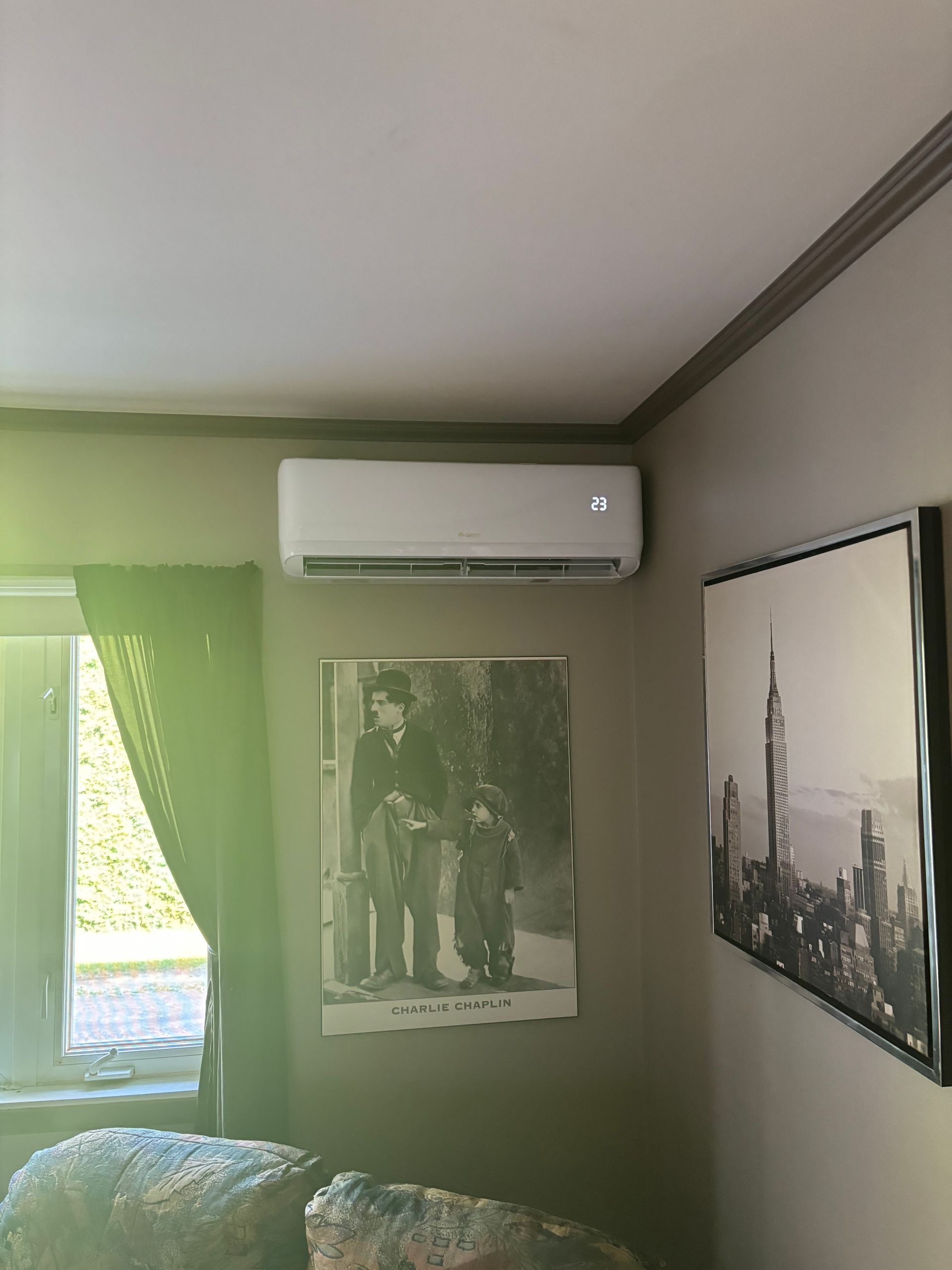 Une pièce avec un tableau sur le mur et un tableau d'une ville sur le mur.