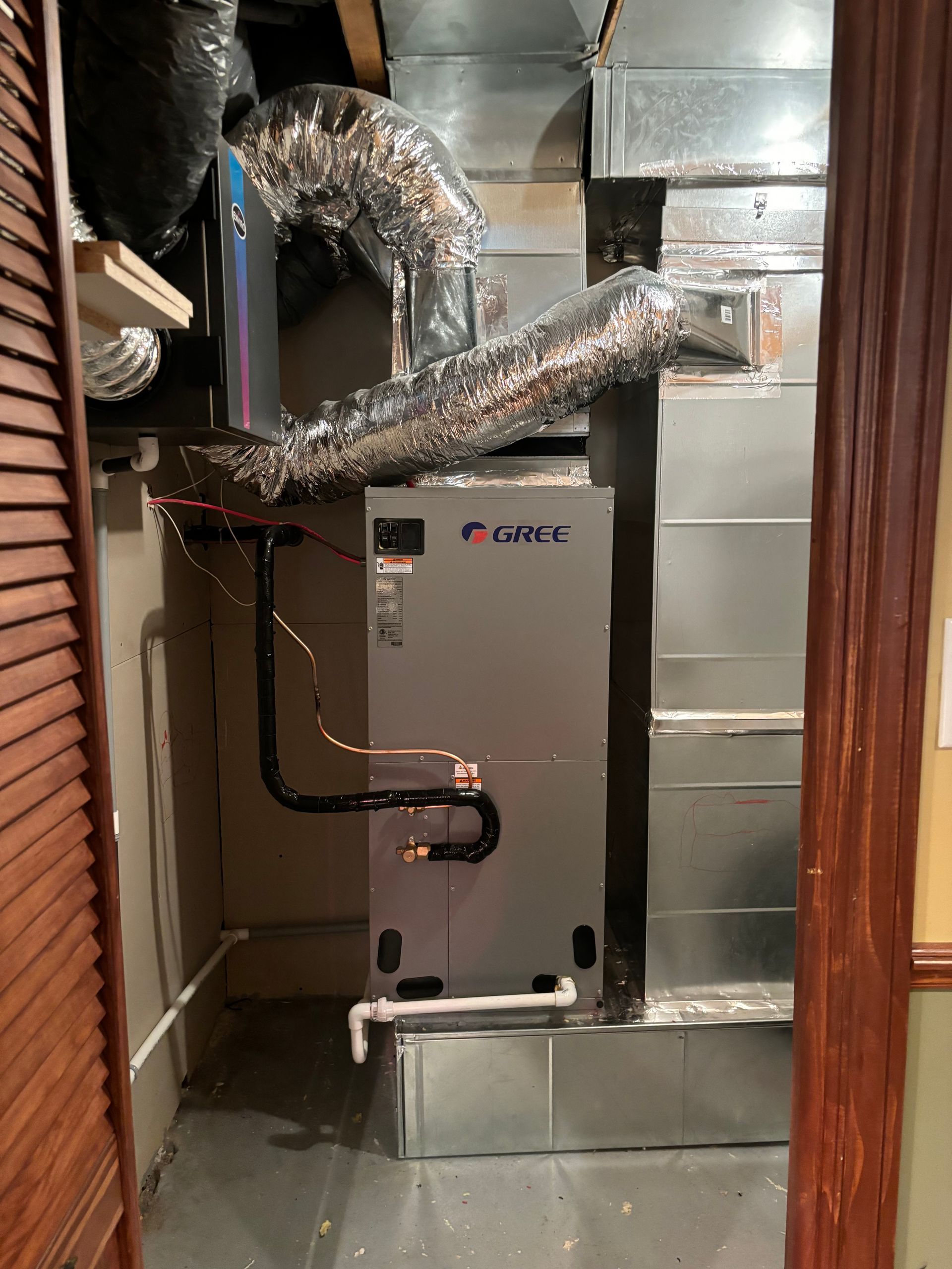 Un climatiseur gris est installé dans une pièce à côté d'une porte.