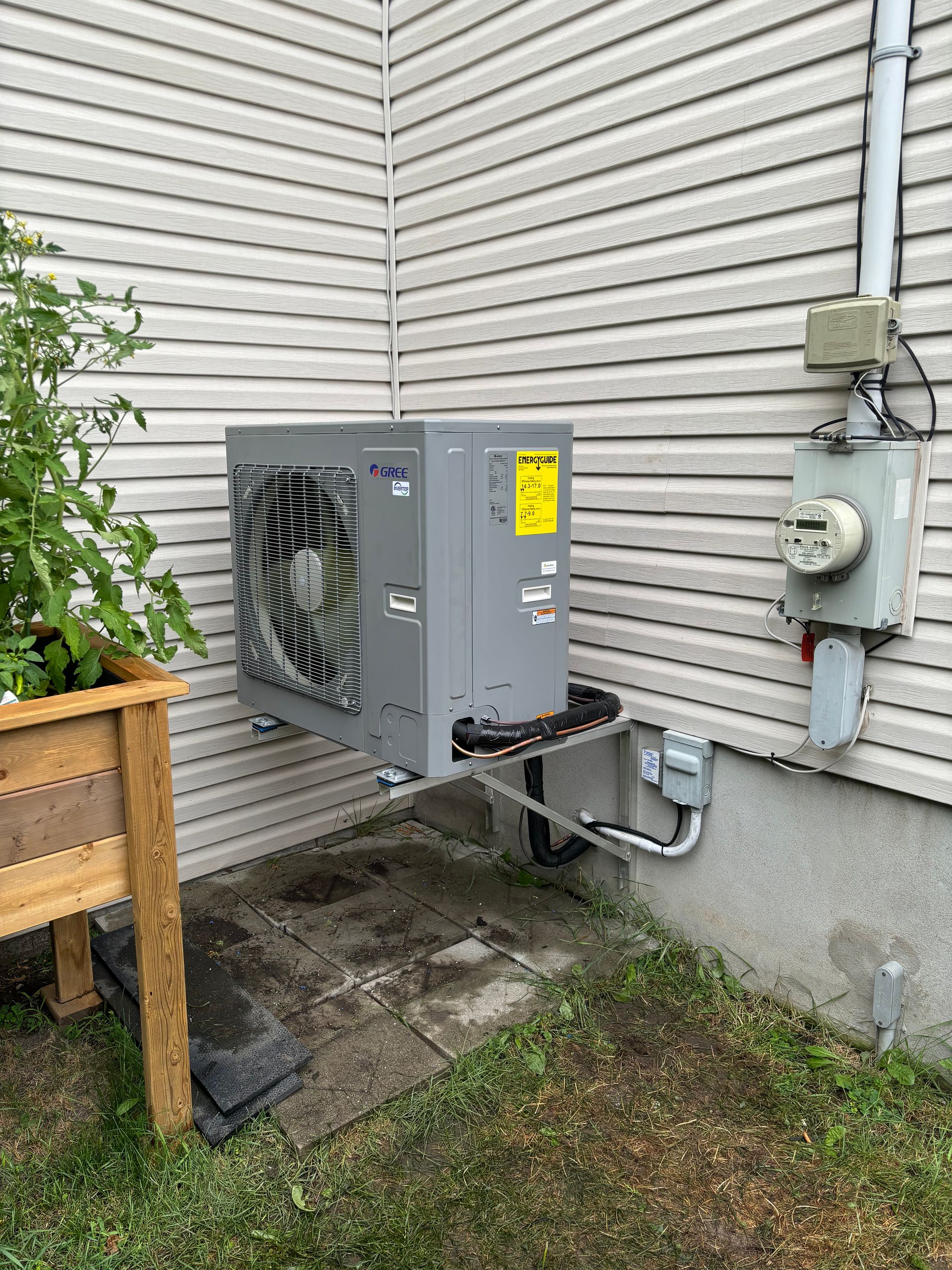 Un climatiseur est installé sur le côté d'une maison.