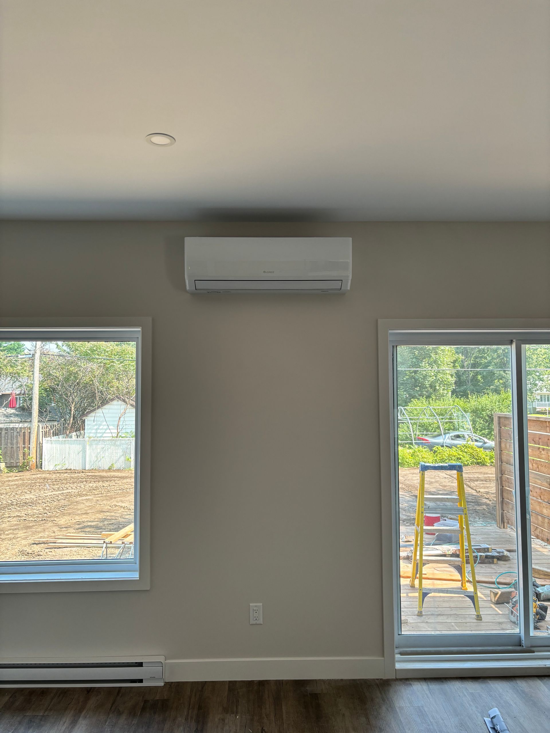 Une pièce avec deux fenêtres et une échelle à l'intérieur.