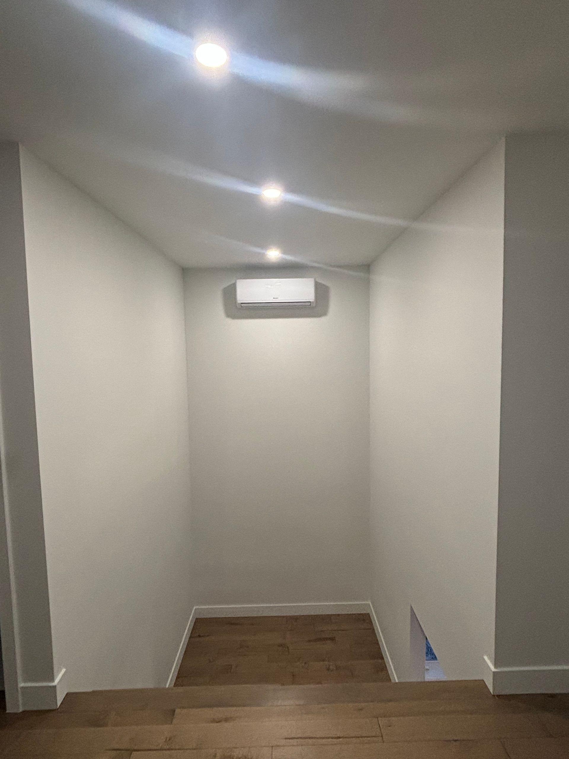 Un couloir avec des escaliers menant au deuxième étage d'une maison.