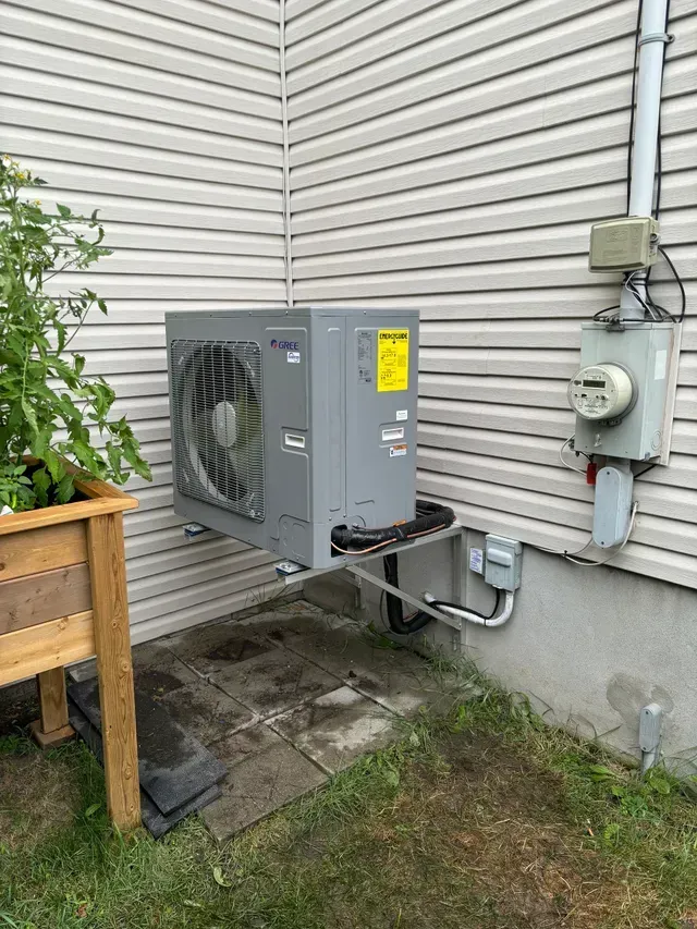 Un climatiseur est installé sur le côté d'une maison.