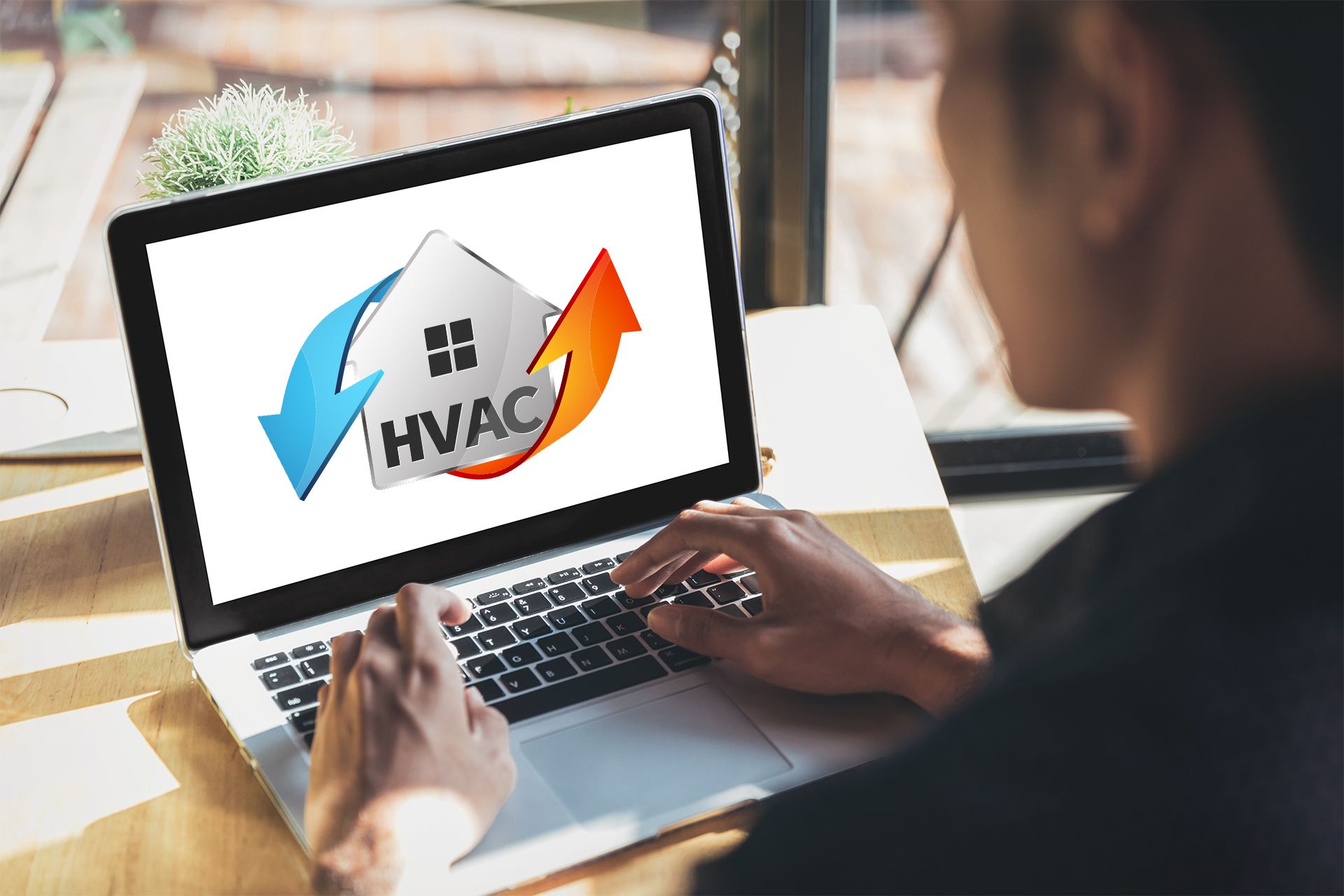 a man is using a laptop computer with a logo for hvac on the screen .