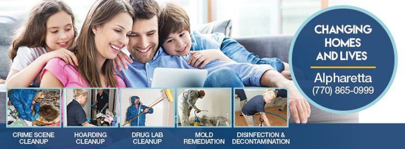 a family is sitting on a couch looking at a laptop computer .