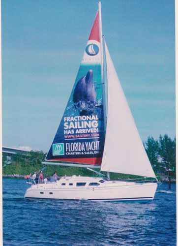 A sailboat with an advertisement for fractional sailing on the sail