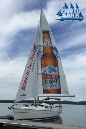 A sailboat with a bottle of coors light on the sail.