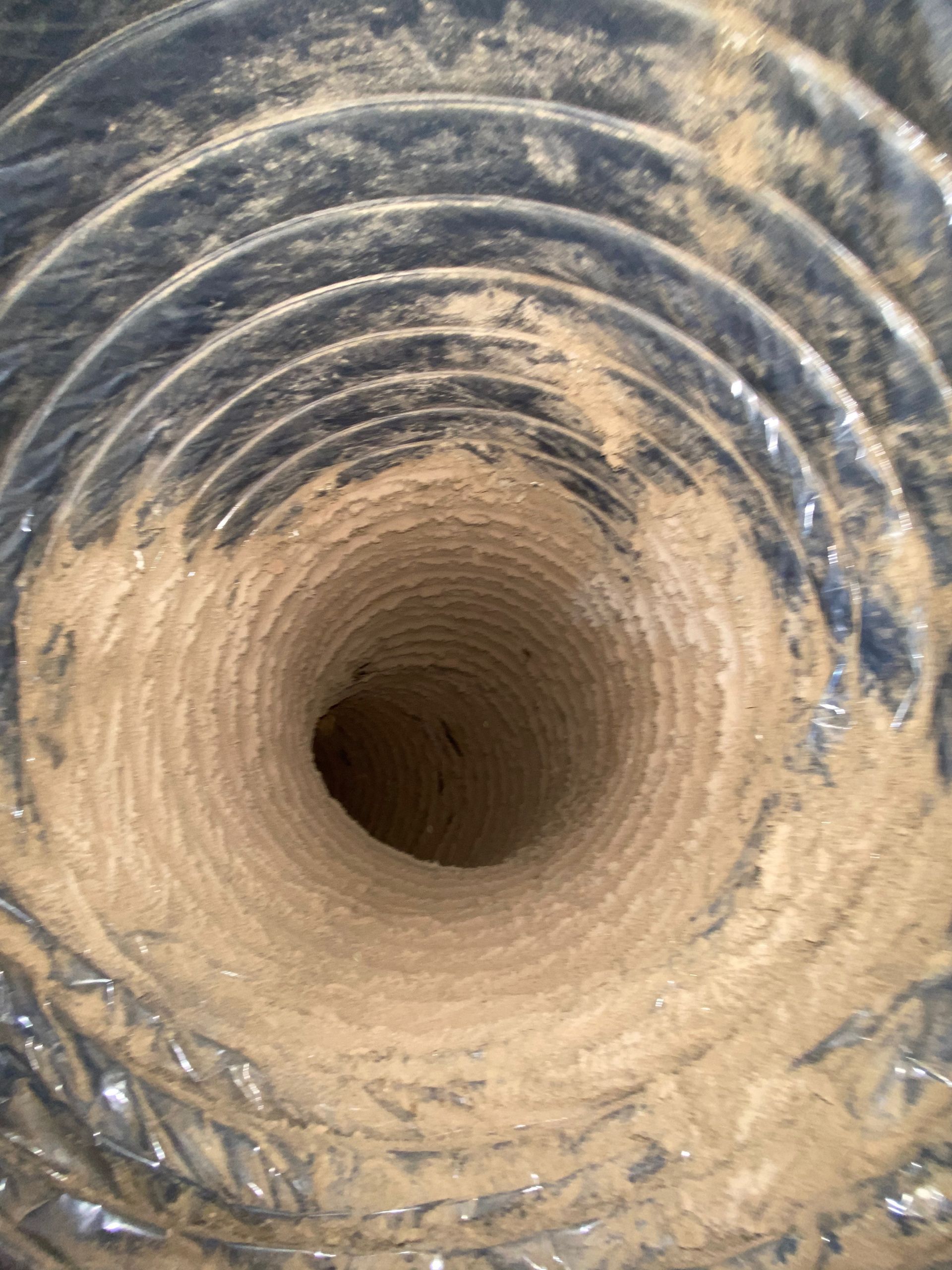 A close up of a dirty duct with a hole in the middle