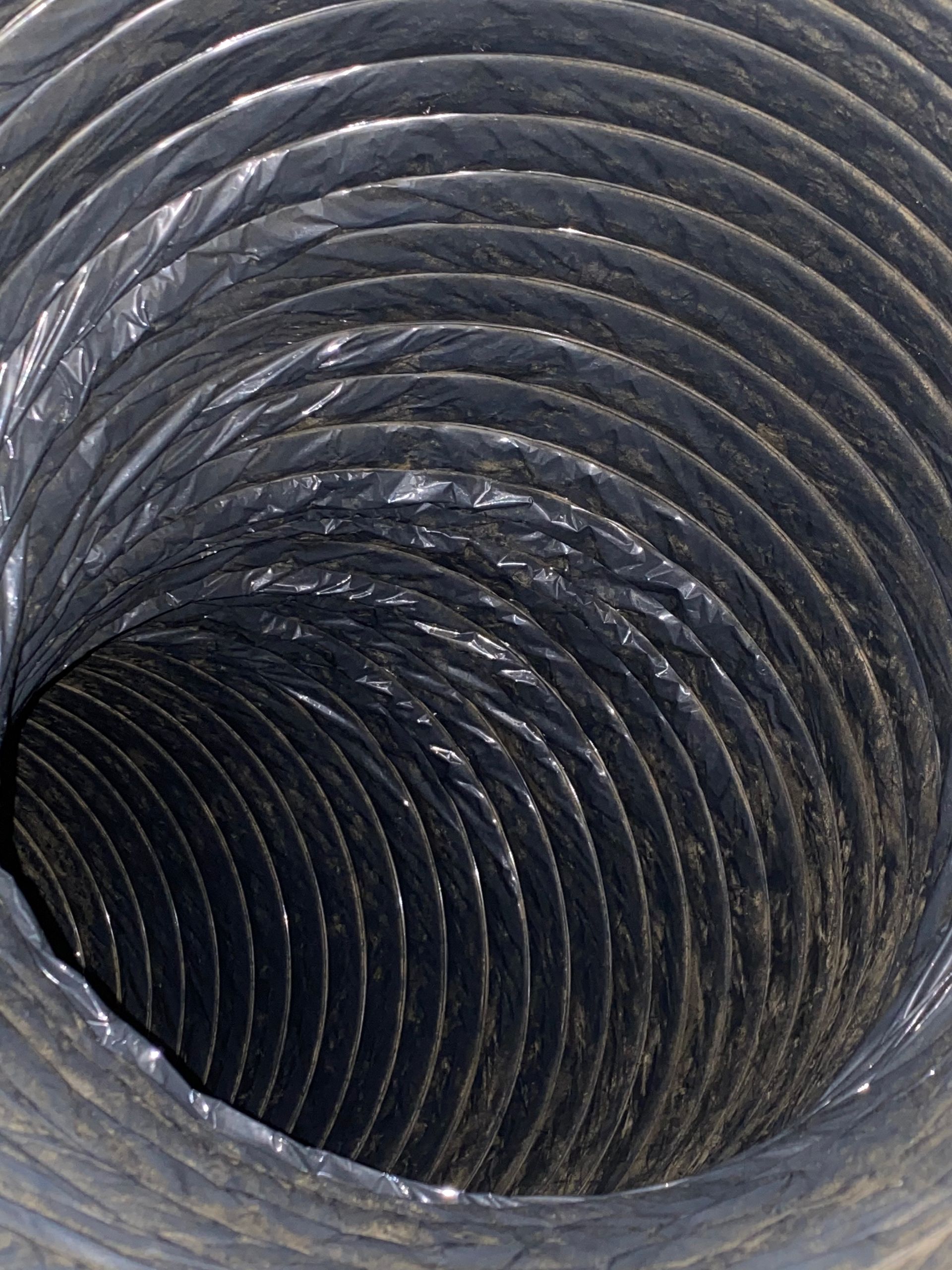 A close up of a black duct with a hole in the middle