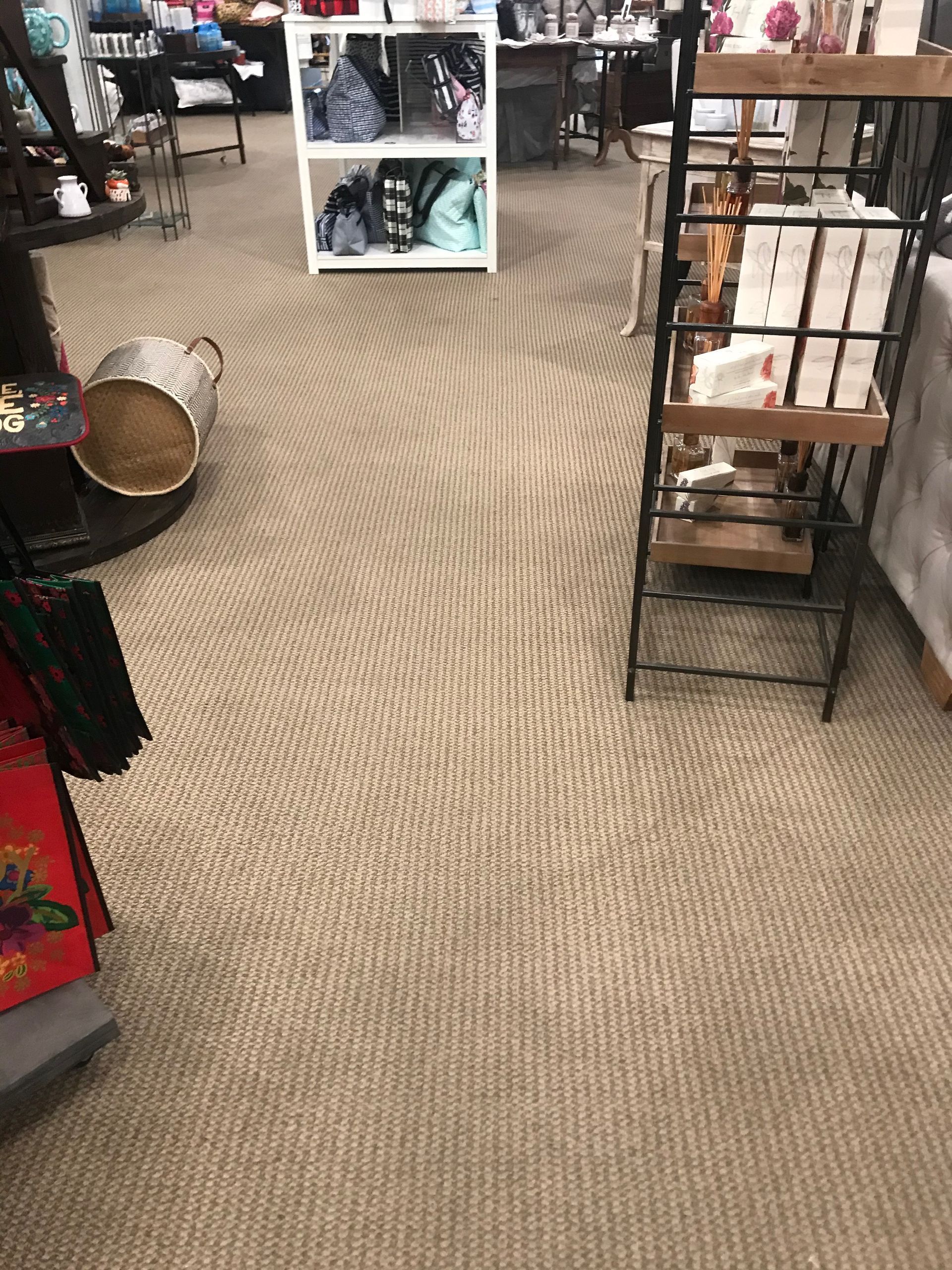 A store with a carpeted floor and a shelf with a basket on it.