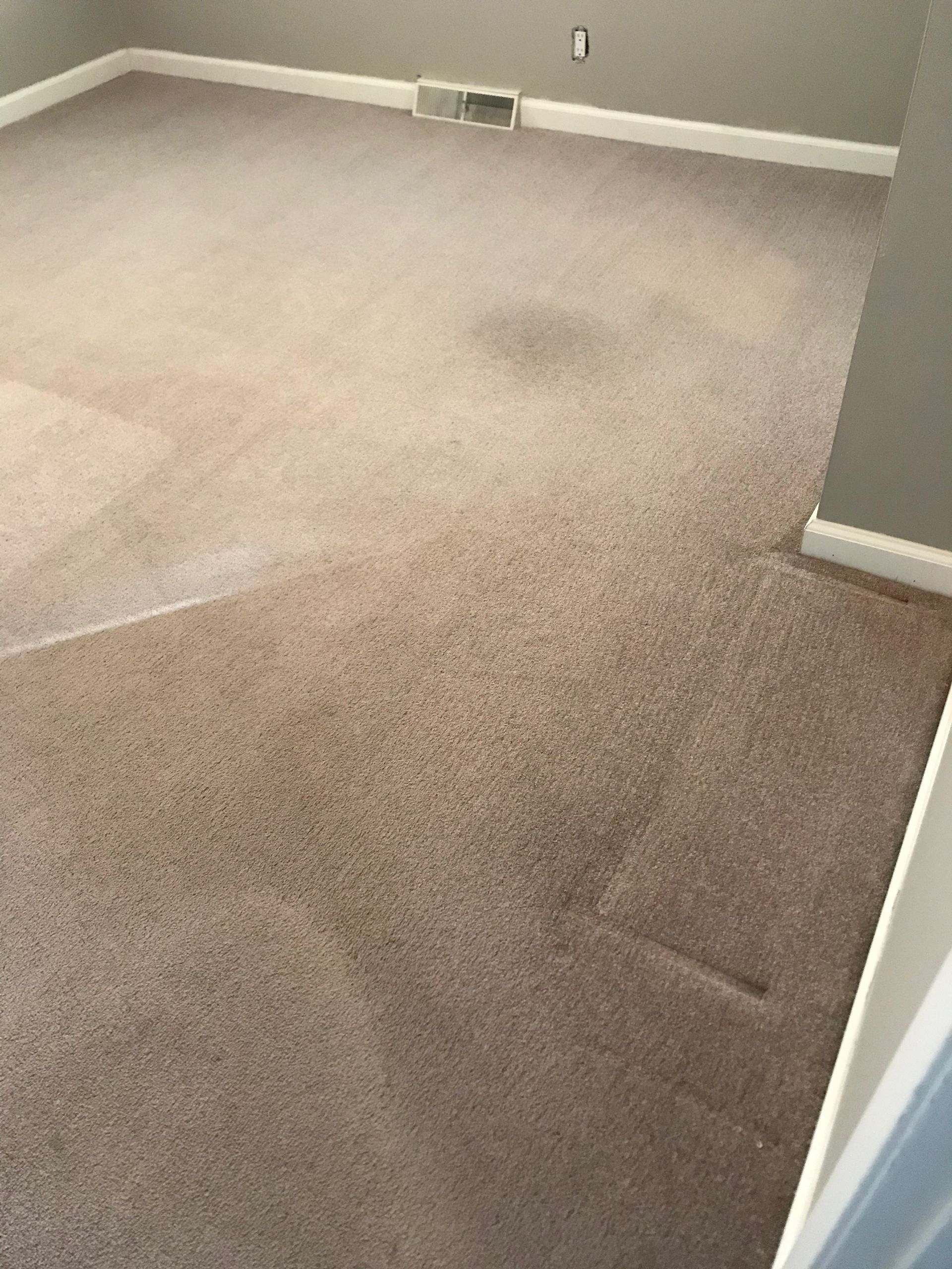 A room with a carpeted floor and a window.