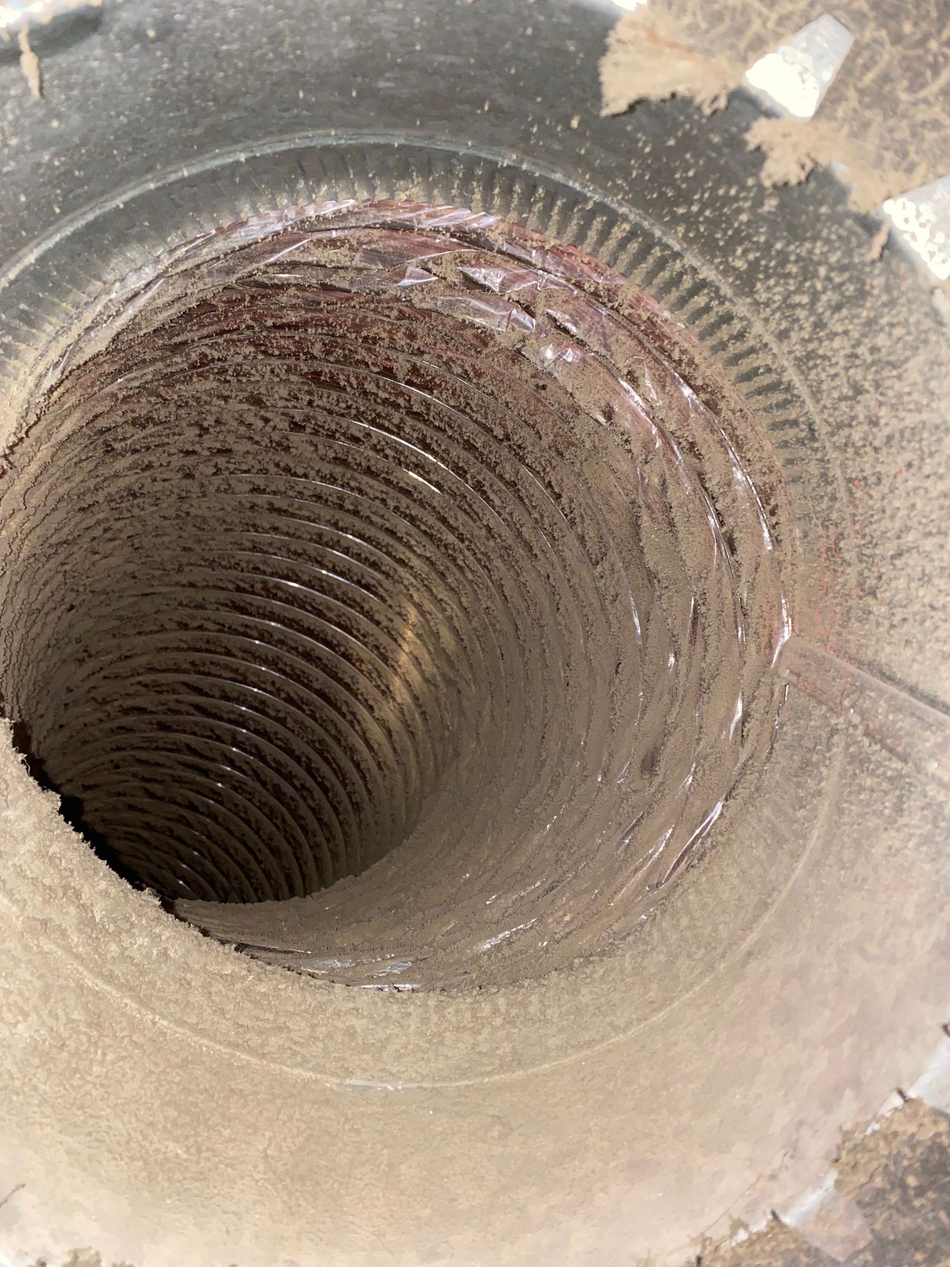 A close up of a dirty air vent with a hole in the middle.