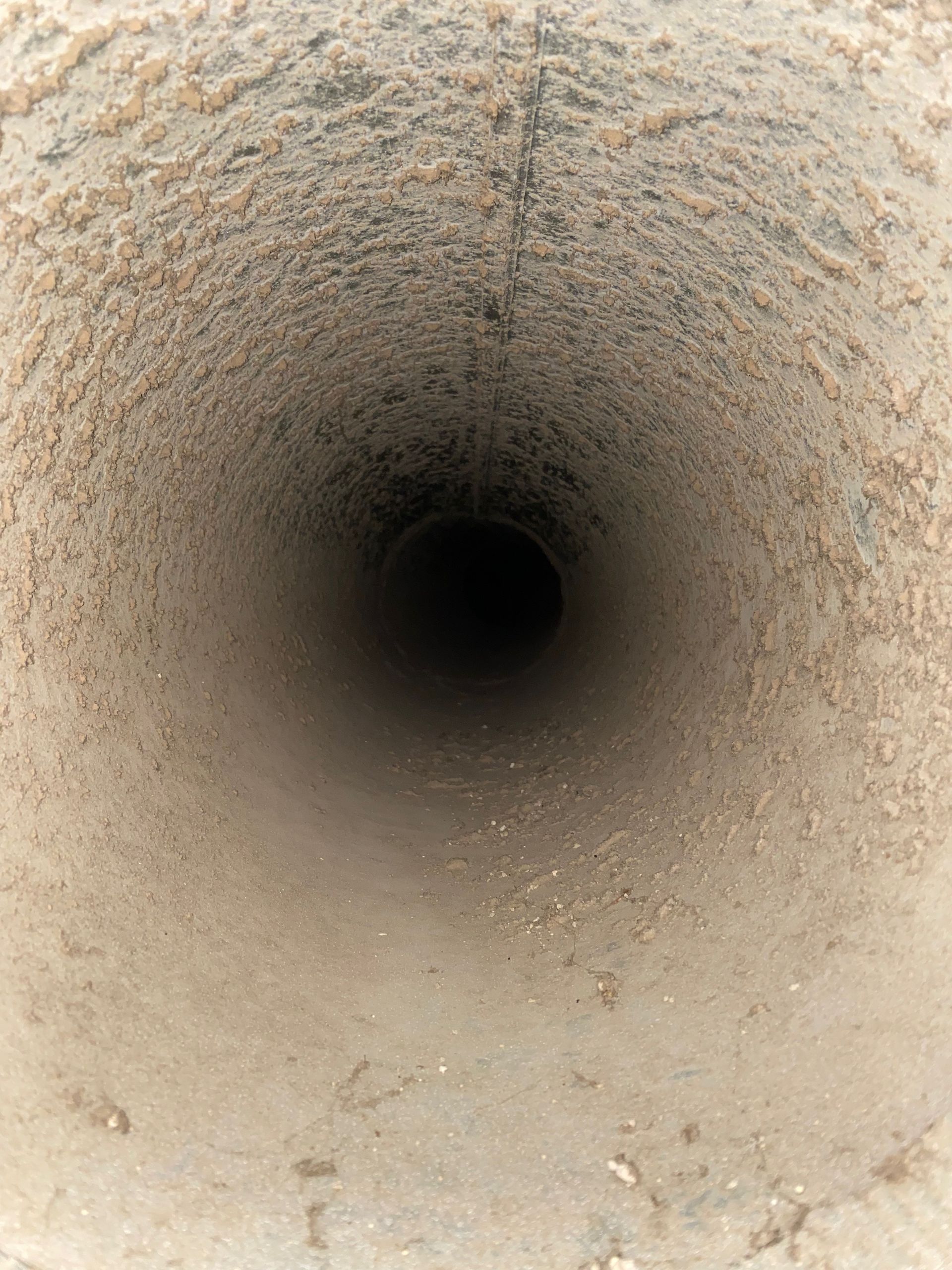 The inside of a dirty pipe with a hole in the middle