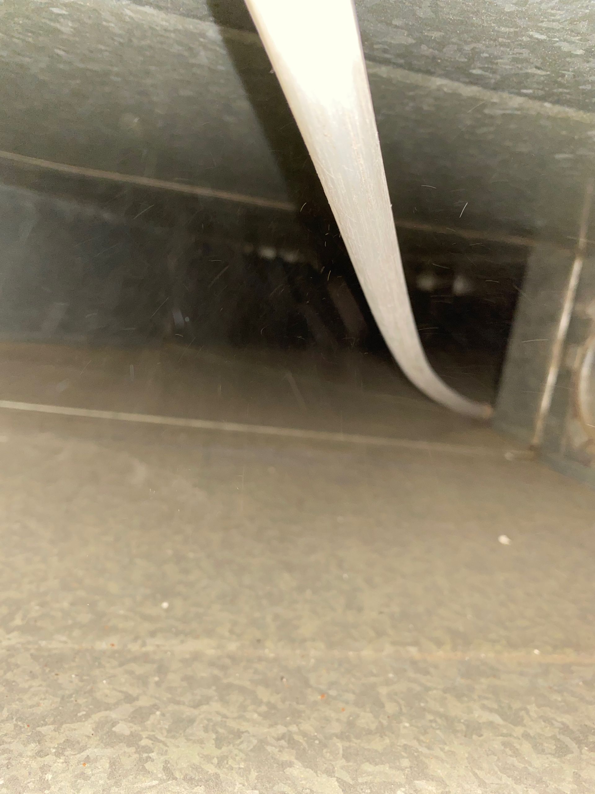 A white hose is hanging from the ceiling of a building.