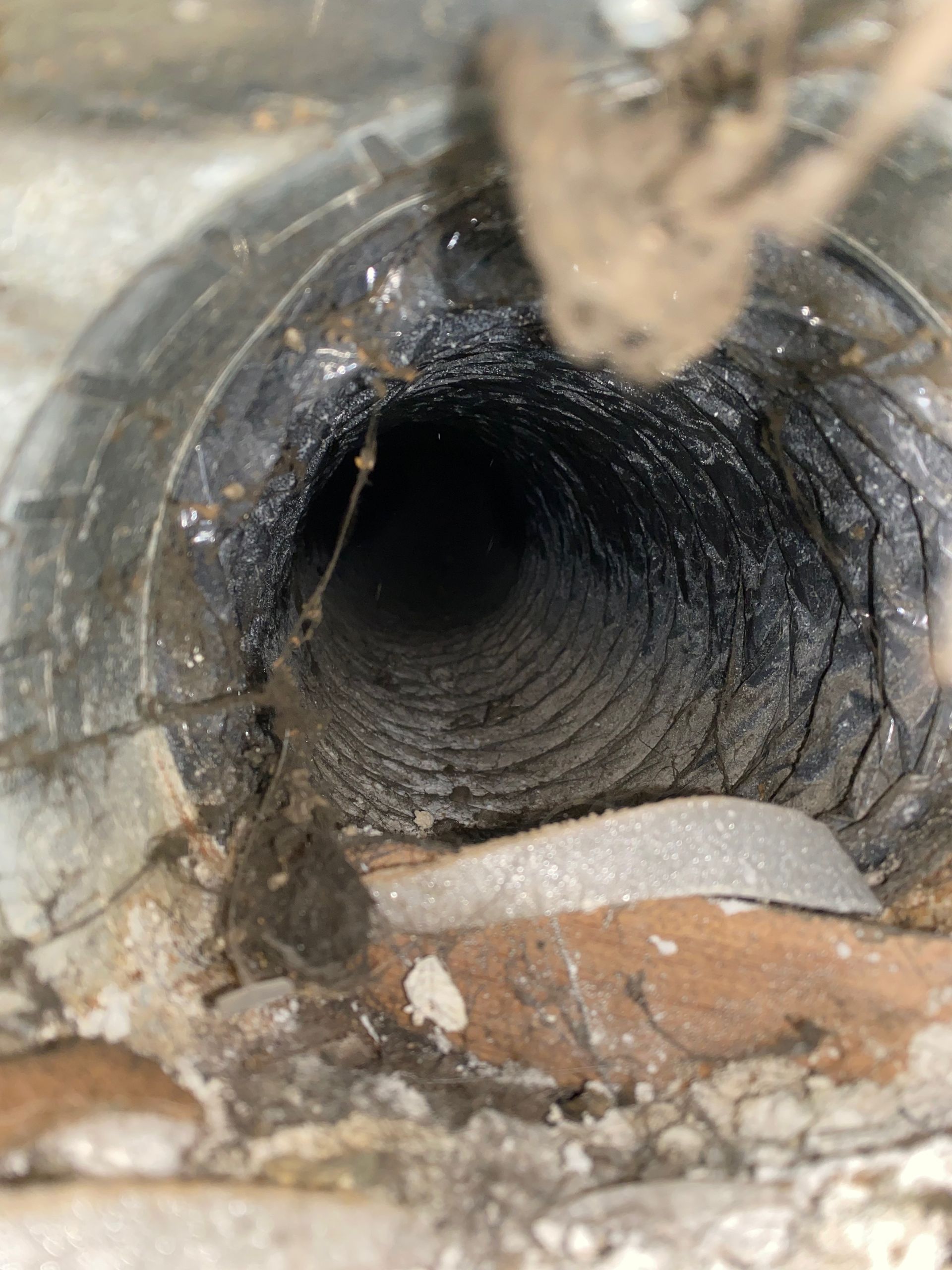 A close up of a dirty duct that looks like a tunnel.