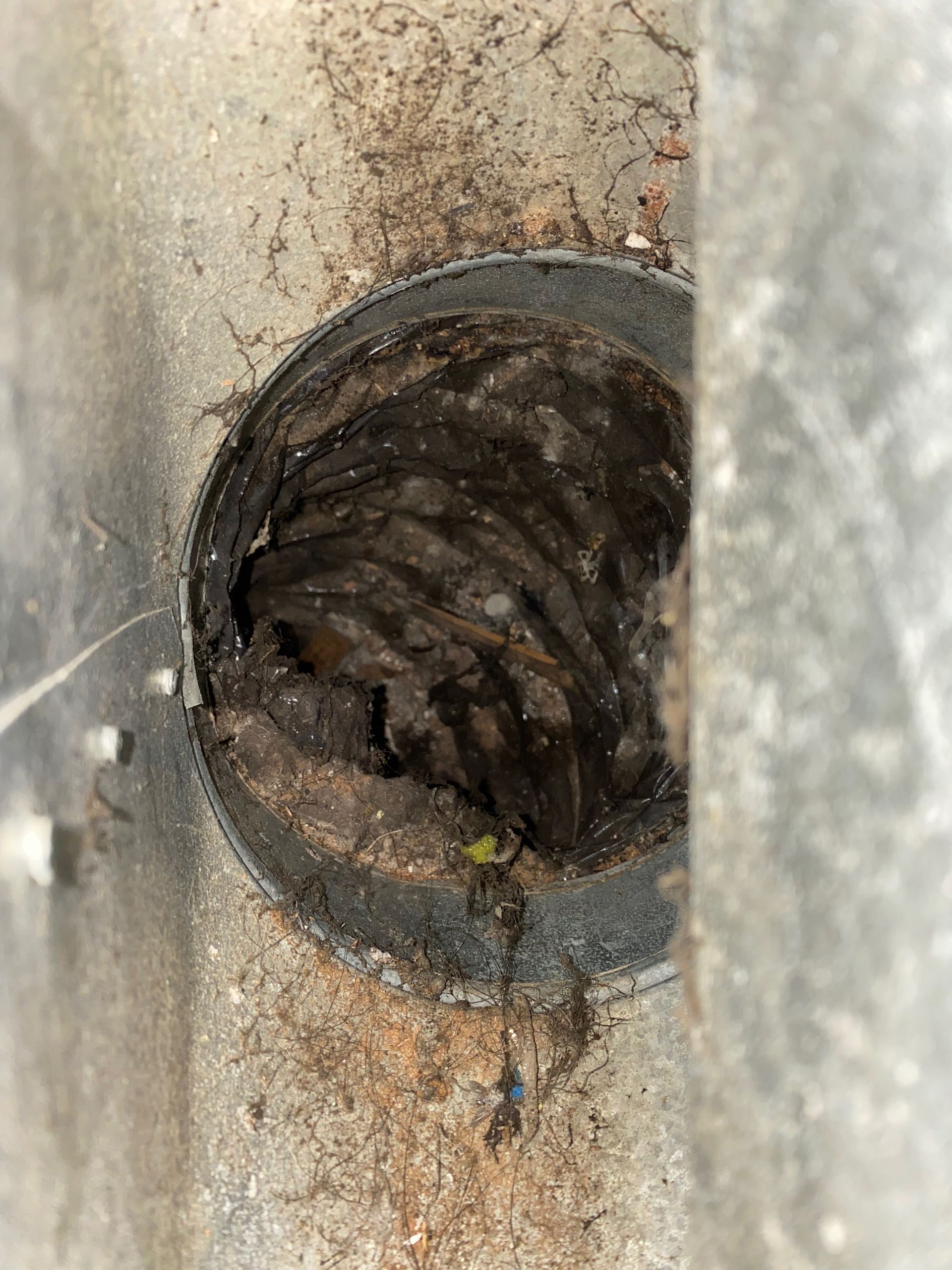 A close up of a dirty air vent on a wall.