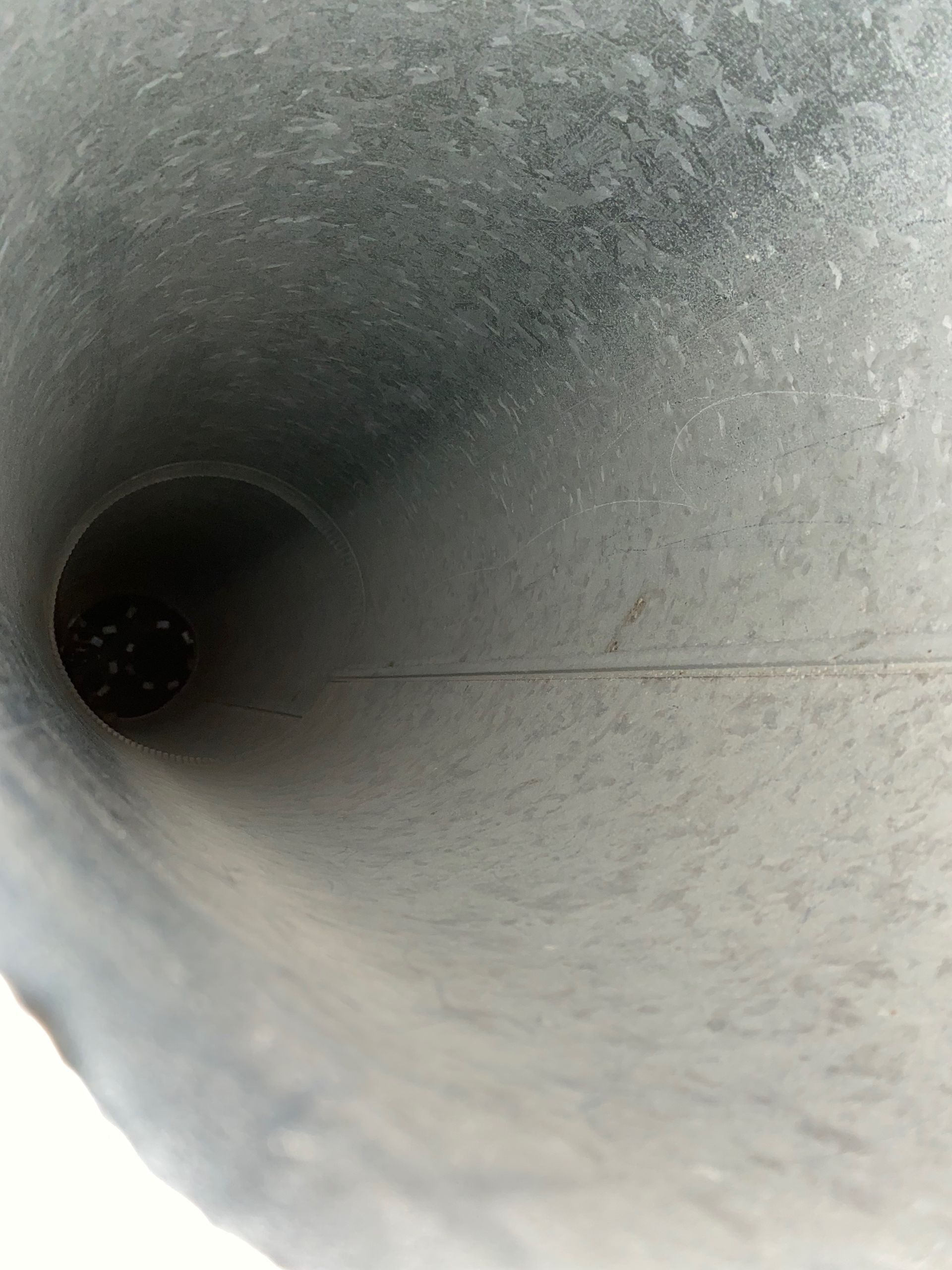A close up of a metal pipe with a hole in the middle.