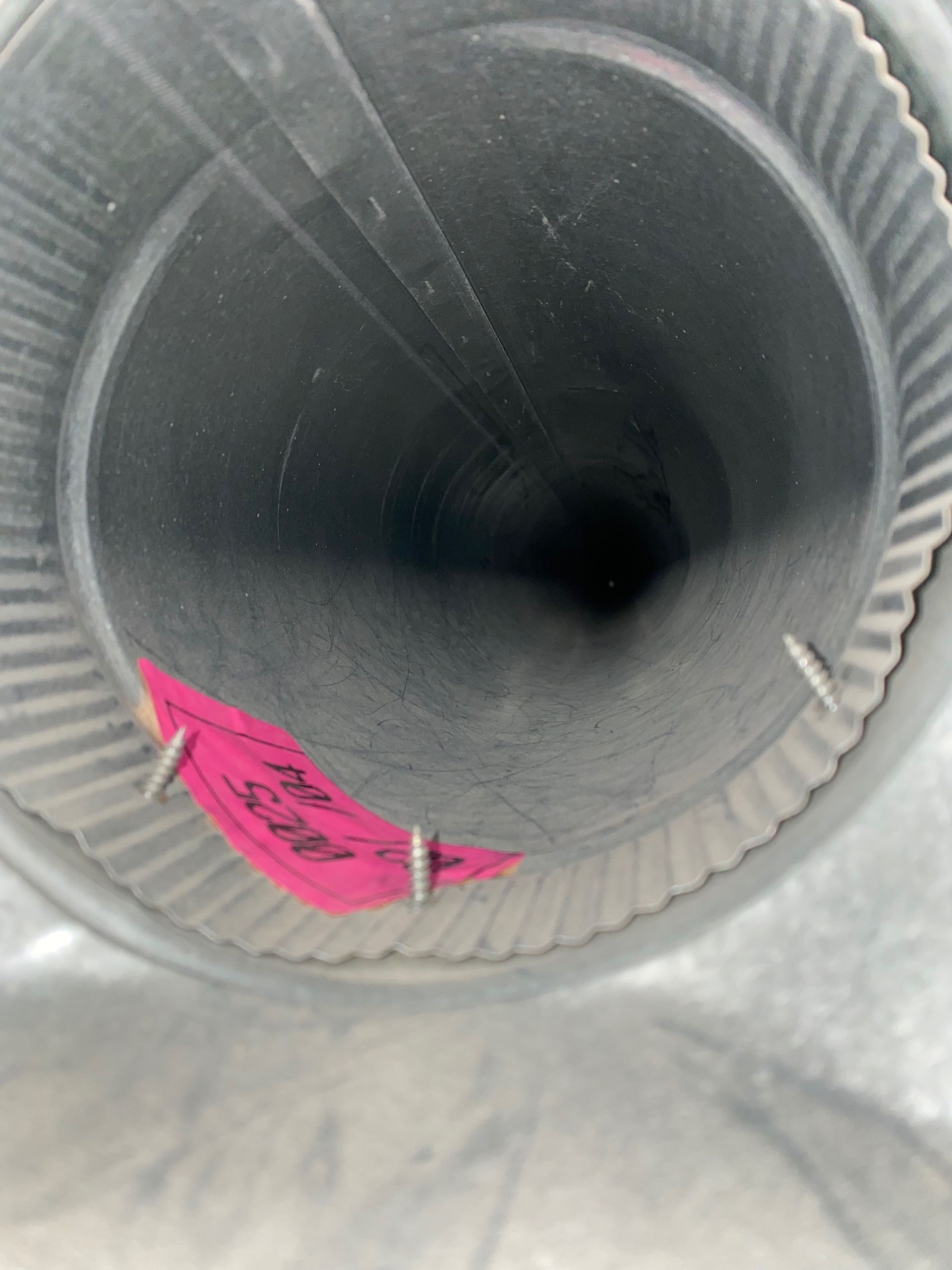 The inside of a metal pipe with a pink tag on it