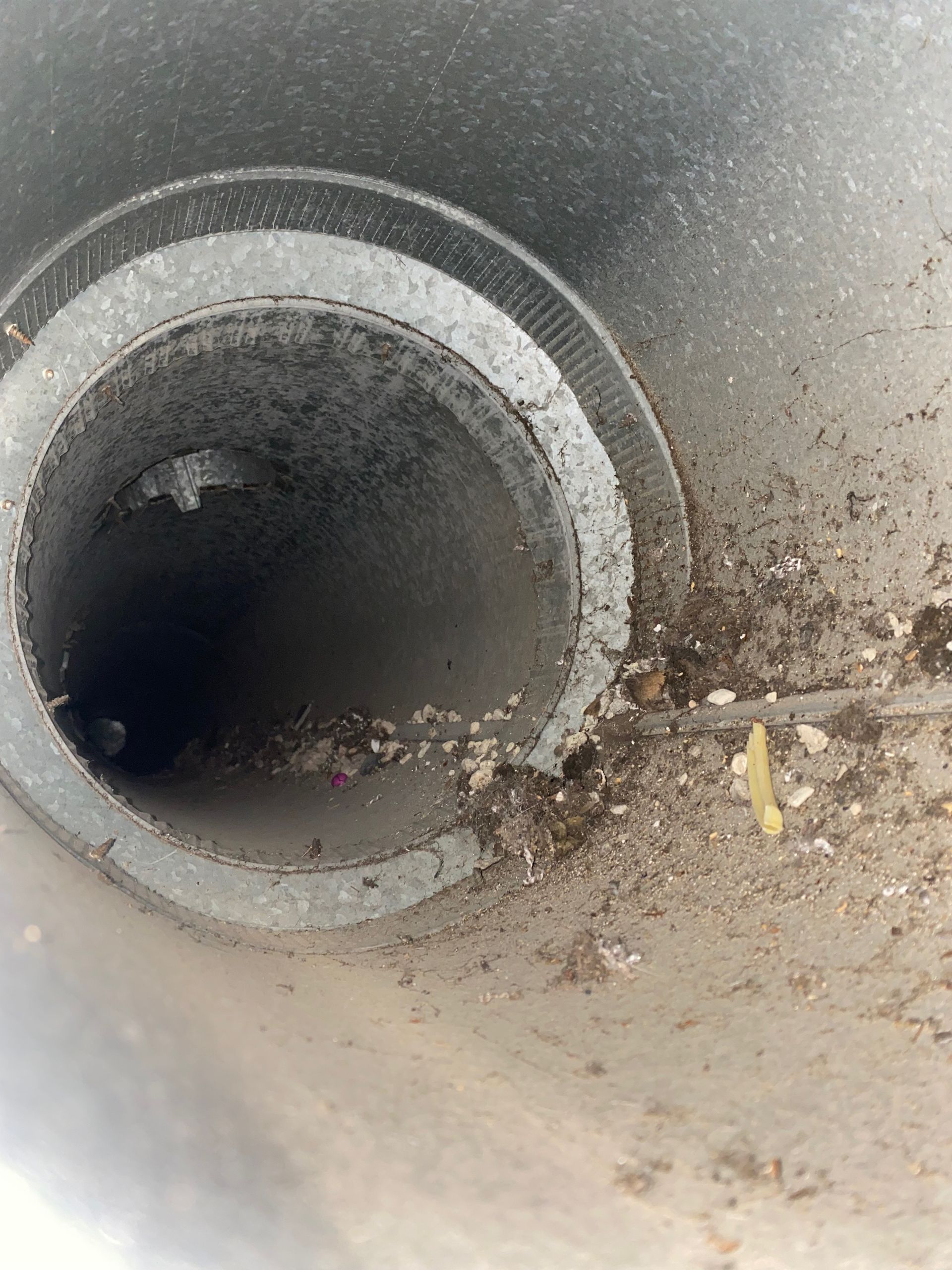 A close up of a dirty pipe with a hole in the middle.