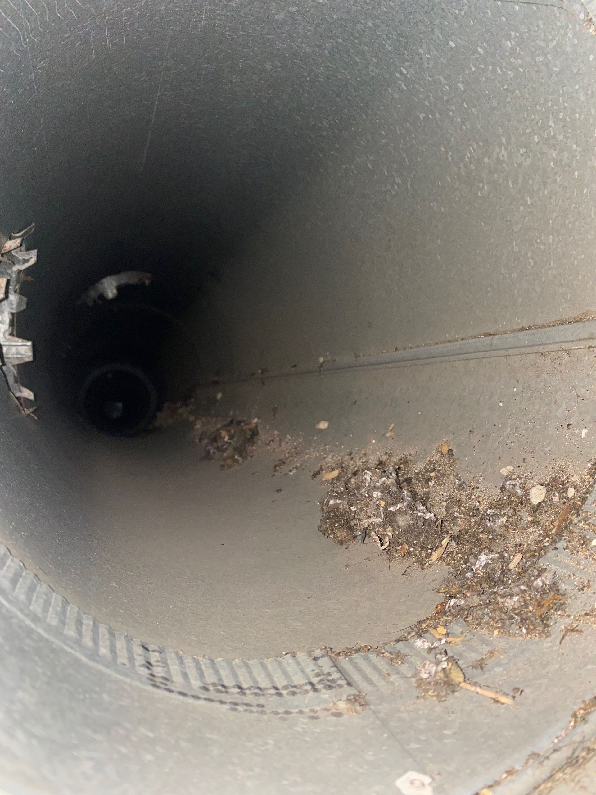 A close up of a dirty pipe with a hole in the middle