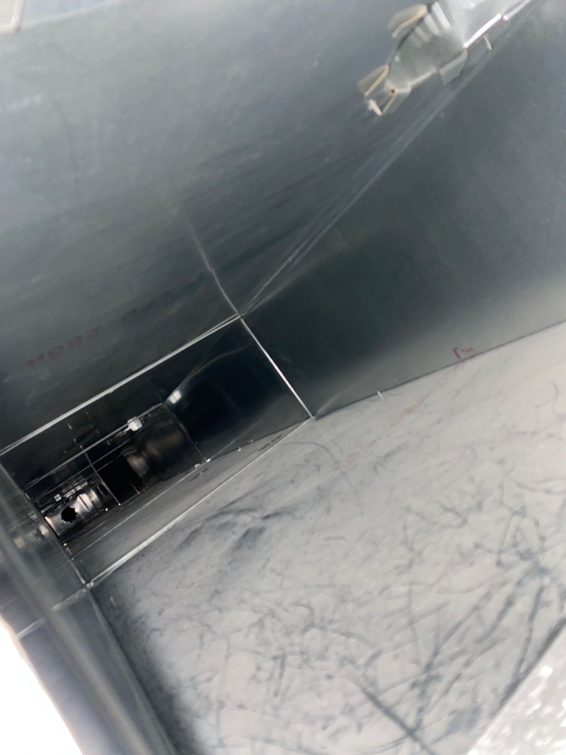 A close up of a black surface with a reflection of a person in it