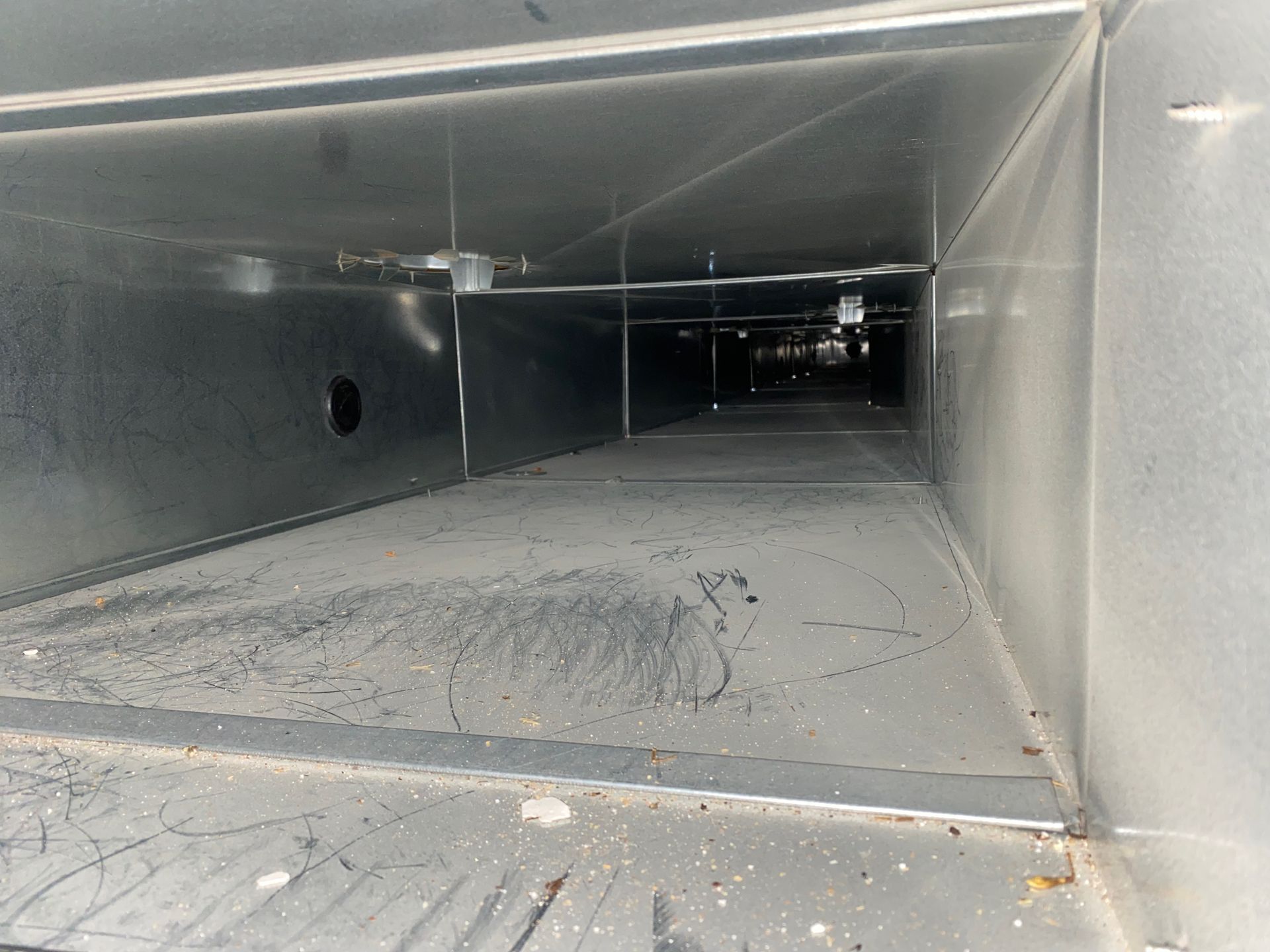 A very long metal duct with a hole in the middle