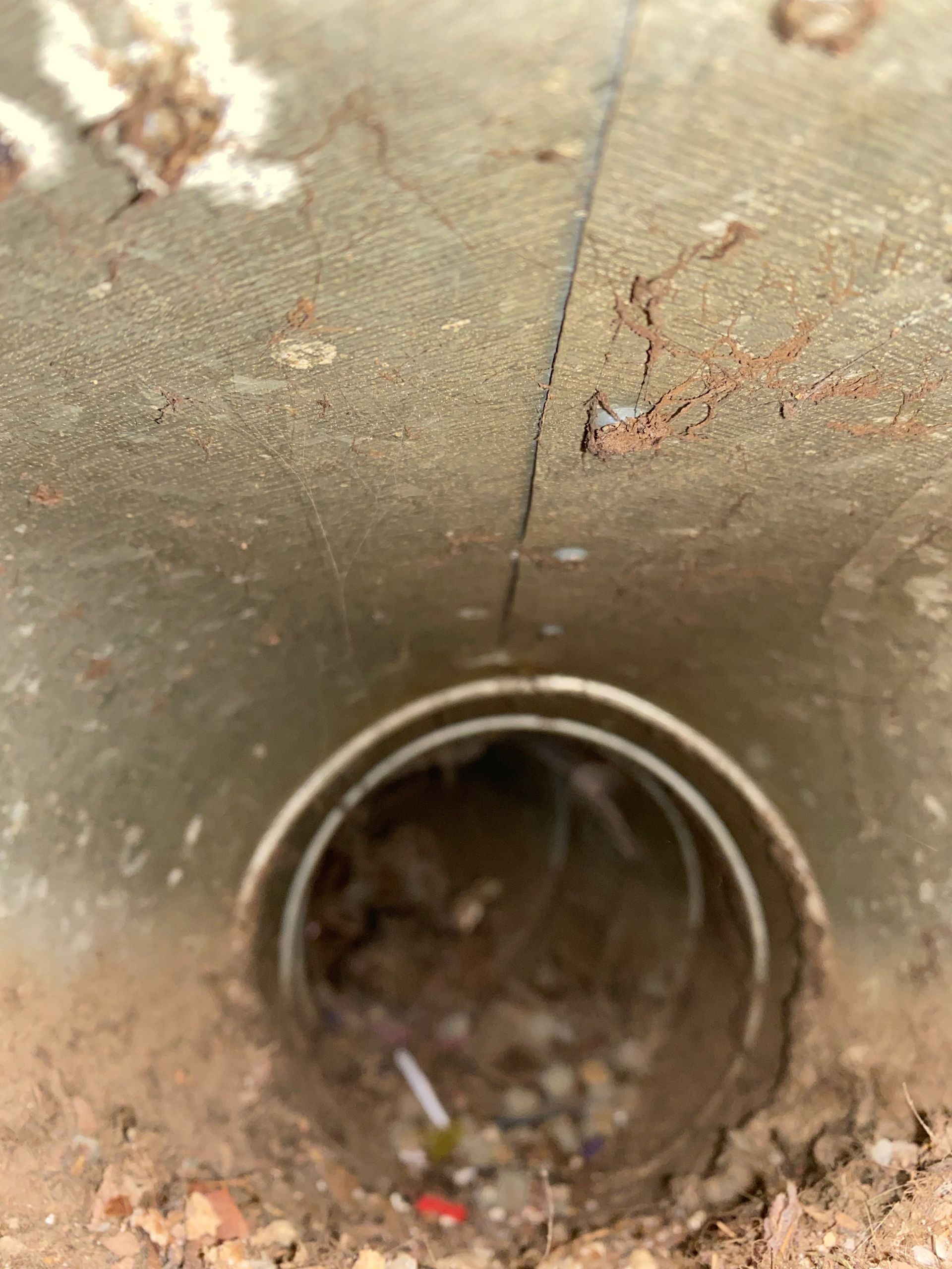 A close up of a metal pipe in the ground.