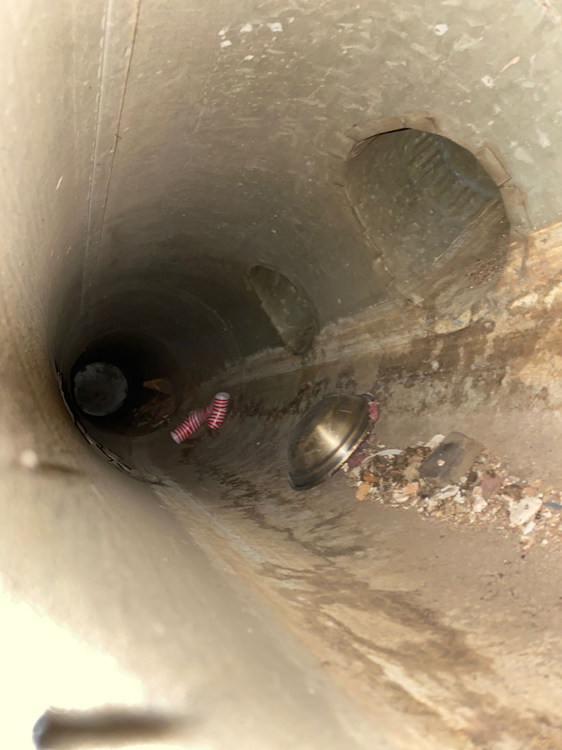 A person is standing in the middle of a concrete tunnel.