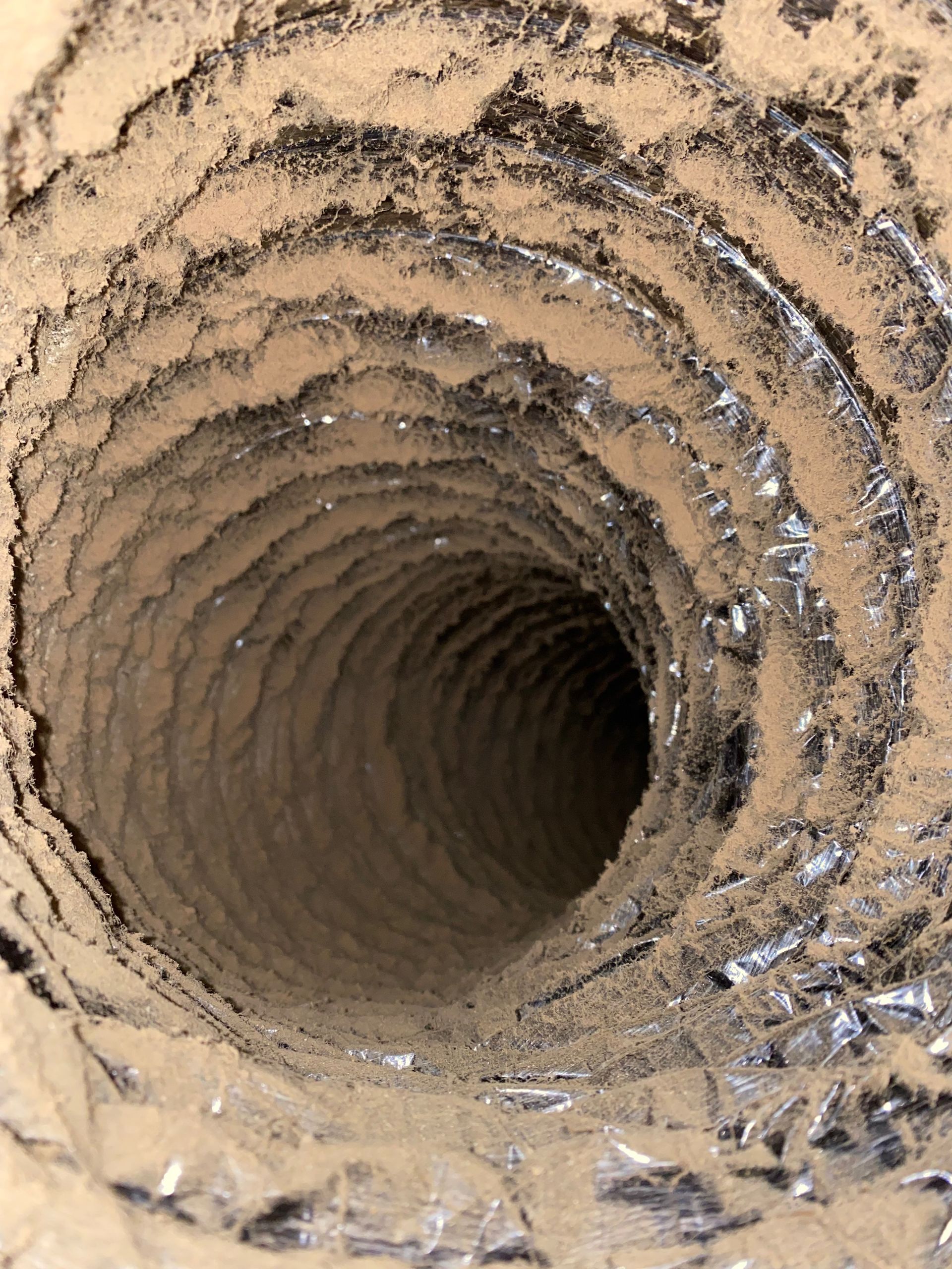 A close up of a dirty duct with a hole in the middle