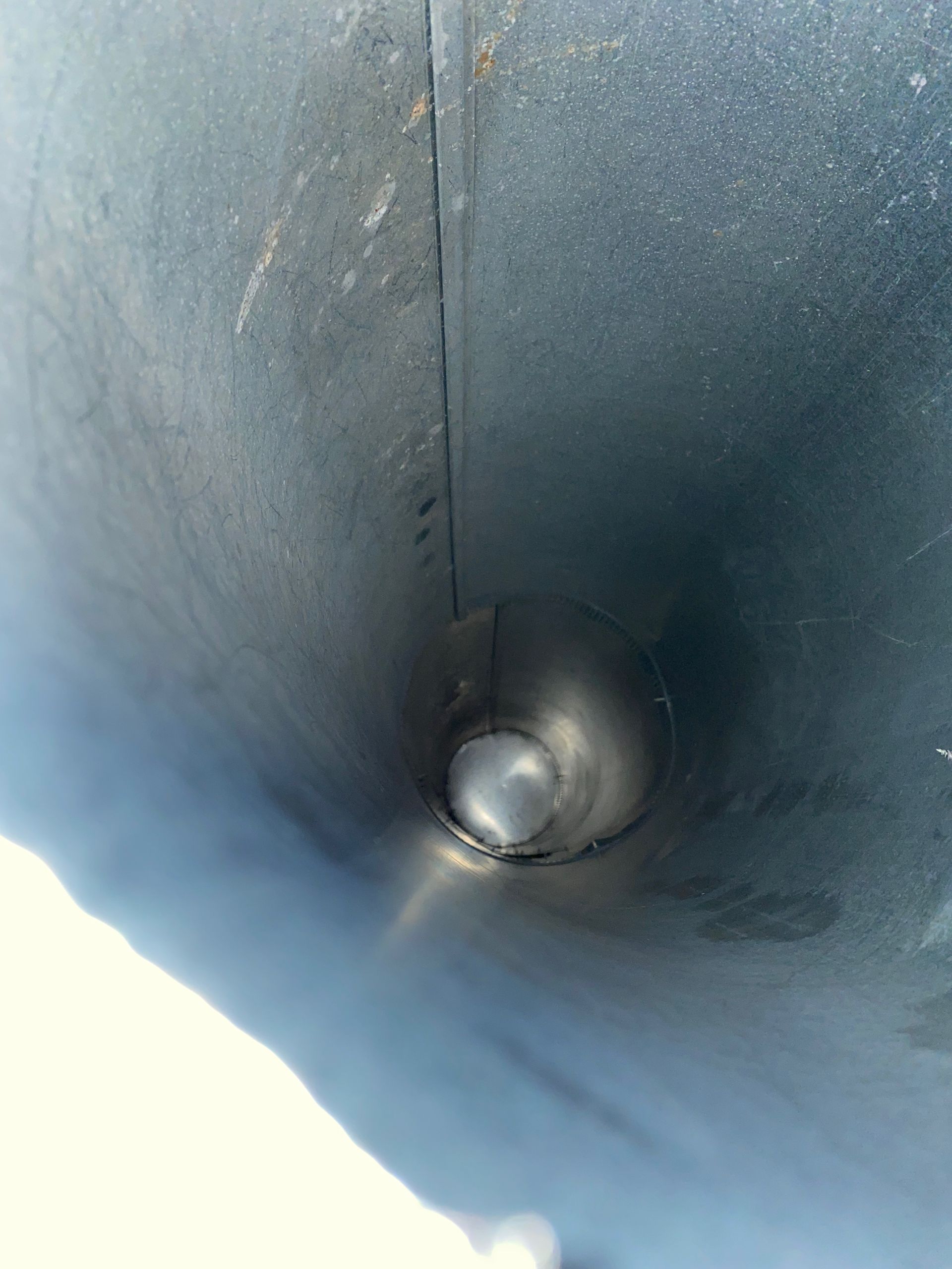 A close up of a metal pipe with a hole in the middle