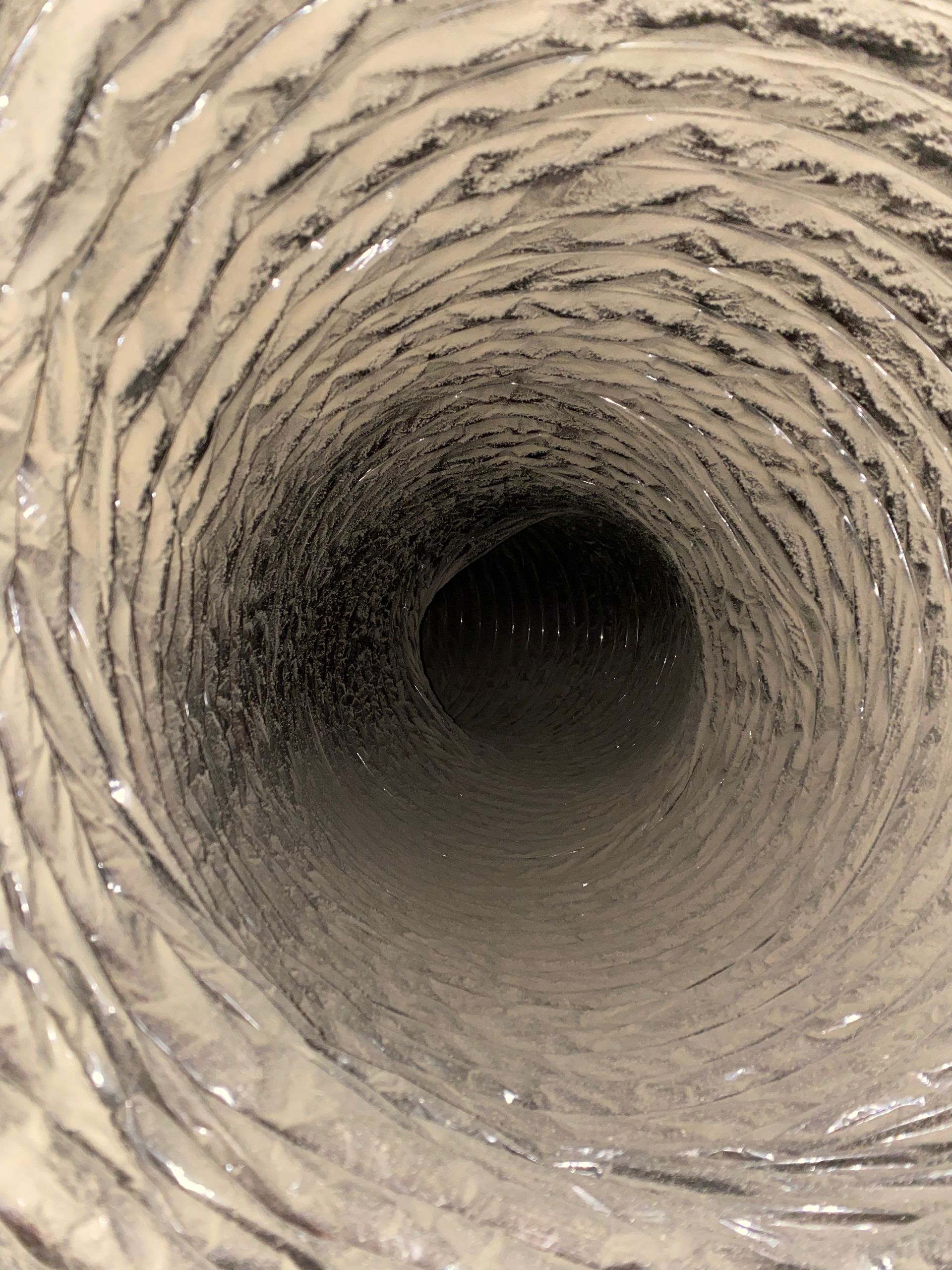 A close up of a dirty air duct with a hole in the middle