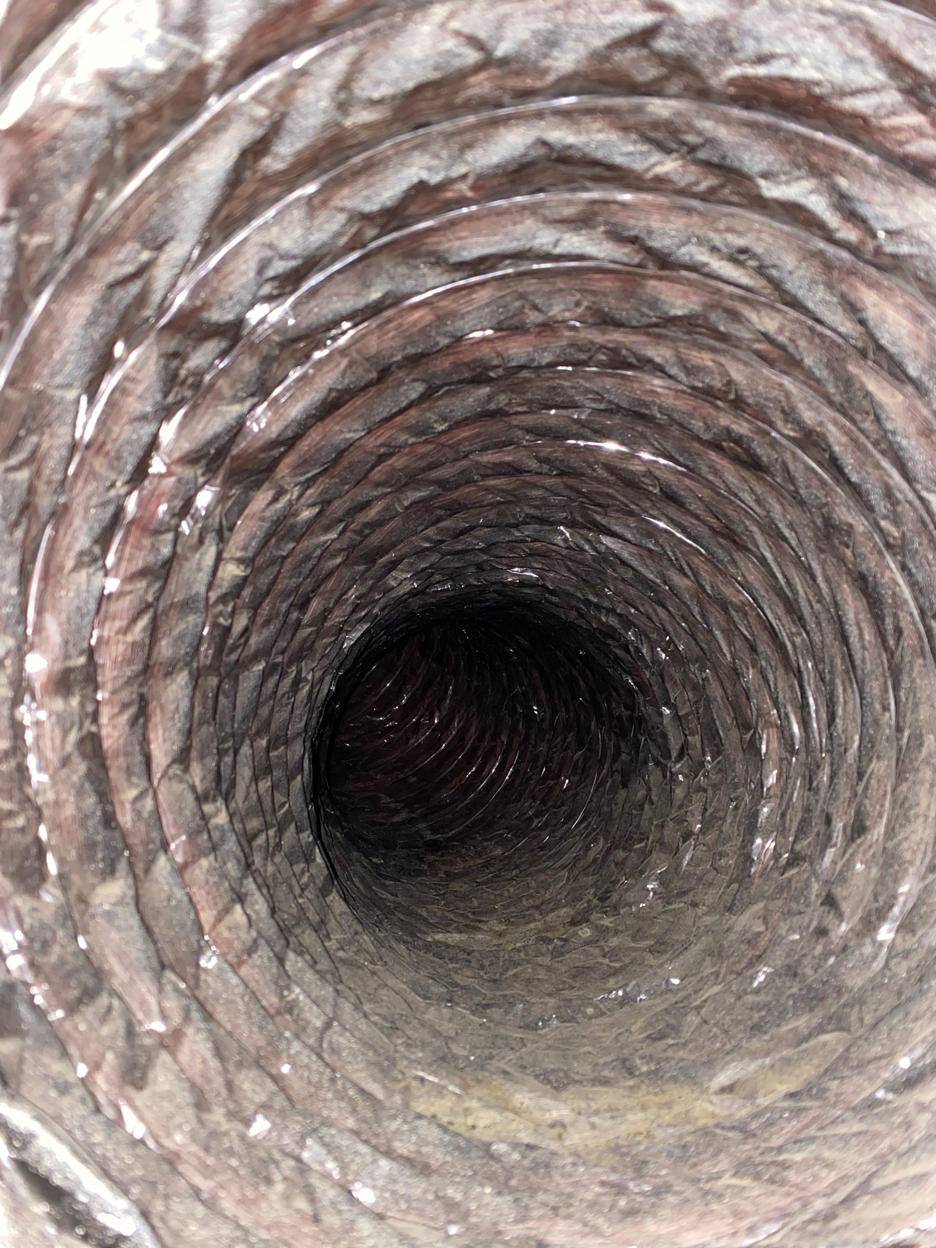 A close up of a dirty air duct with a hole in the middle.