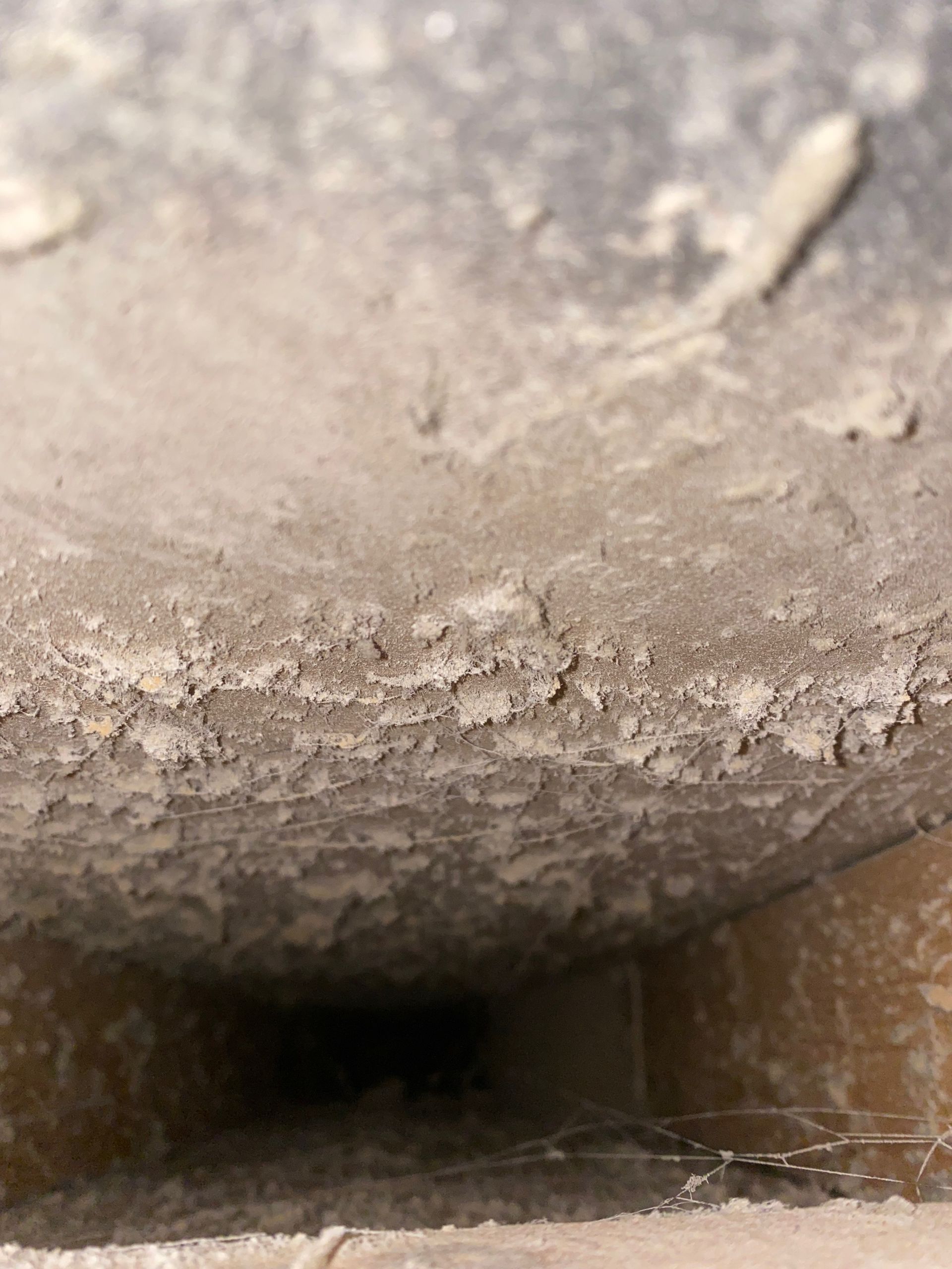 A close up of a dirty wall with a hole in it