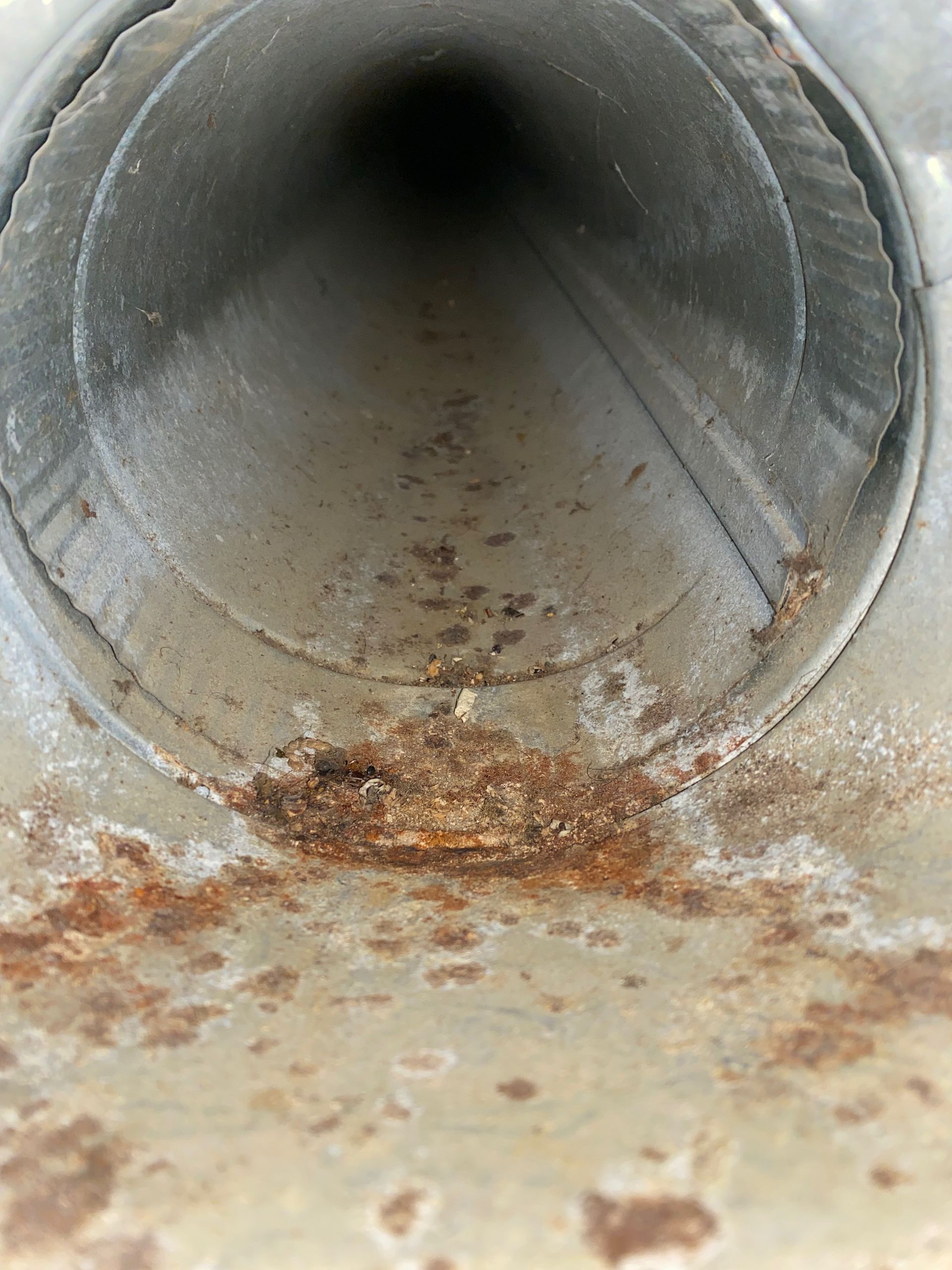 A rusty metal pipe with a hole in the middle