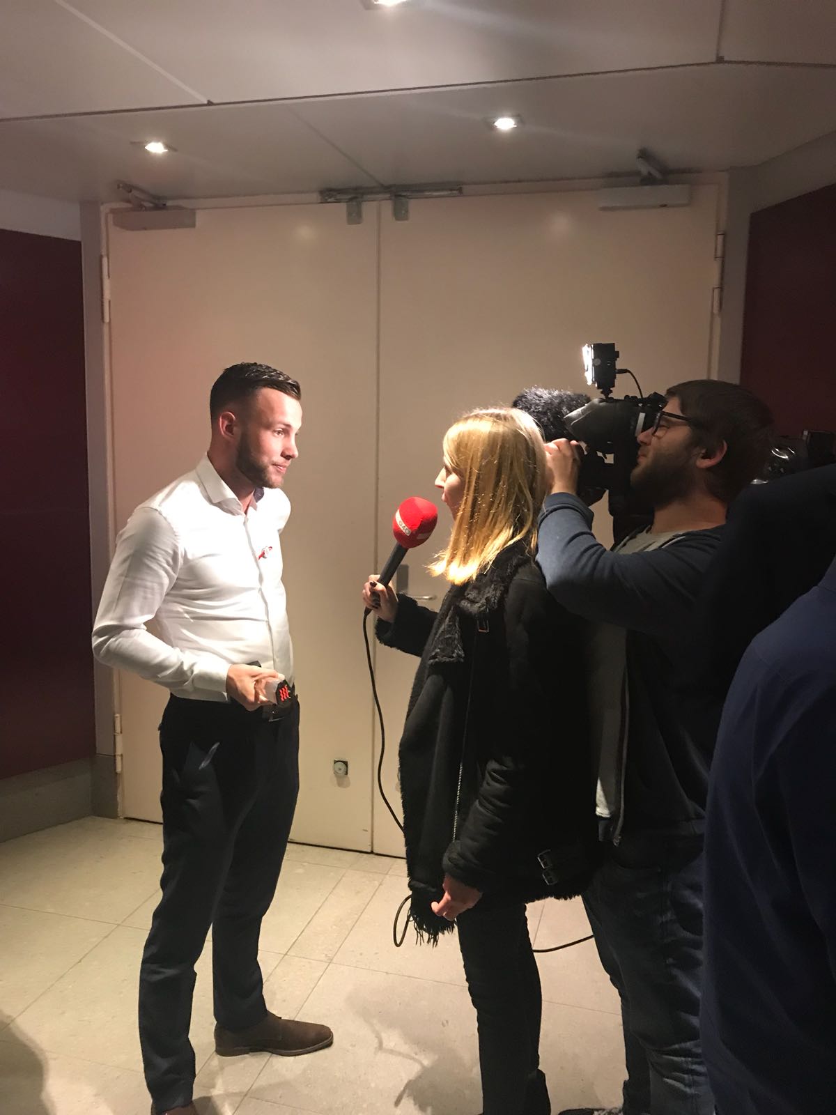 Een man wordt geïnterviewd door een vrouw die een microfoon vasthoudt.