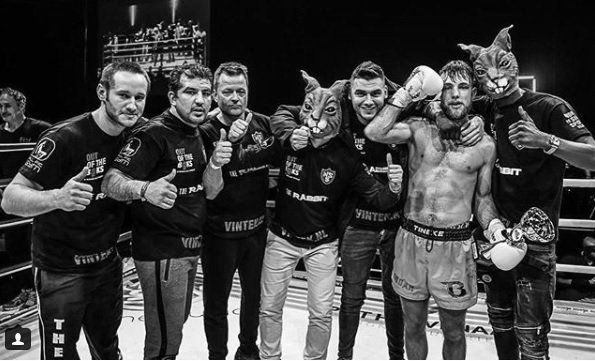 Een groep mannen poseert voor een foto in een boksring.