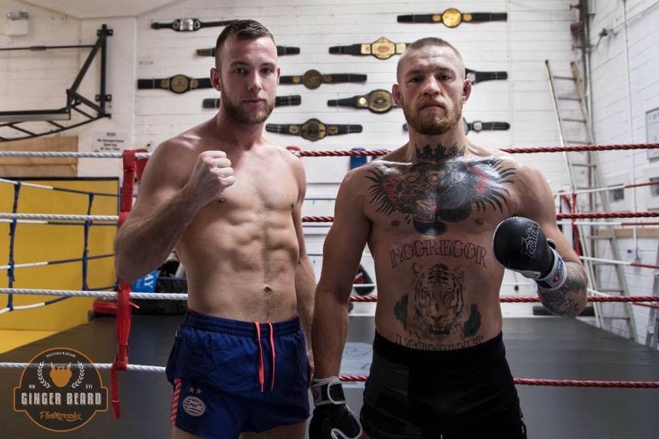 Twee mannen staan ​​naast elkaar in een boksring.