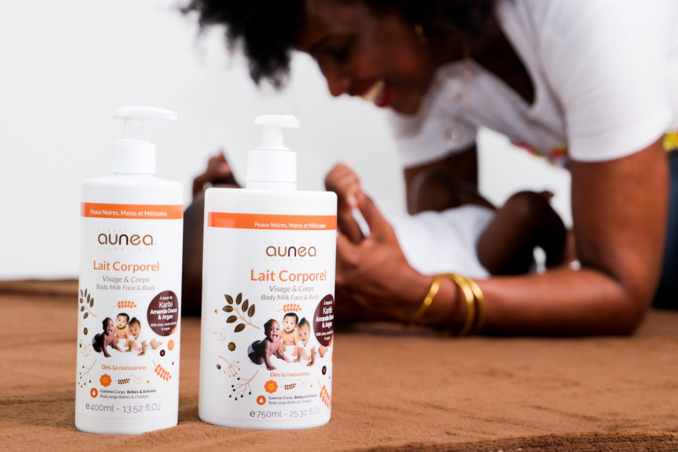 Deux bouteilles de lotion pour bébé devant une mère touchant doucement son bébé, toutes deux sont noires.