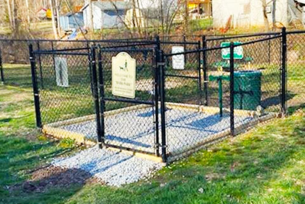 A dog park with a chain link fence and a bench at Old Mill Townhomes in Lynchburg, VA.