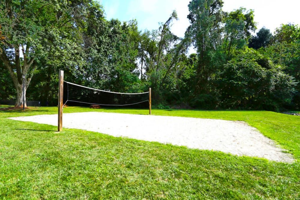 A volleyball net is sitting in the middle of a lush green field at Old Mill Townhomes in Lynchburg, VA.