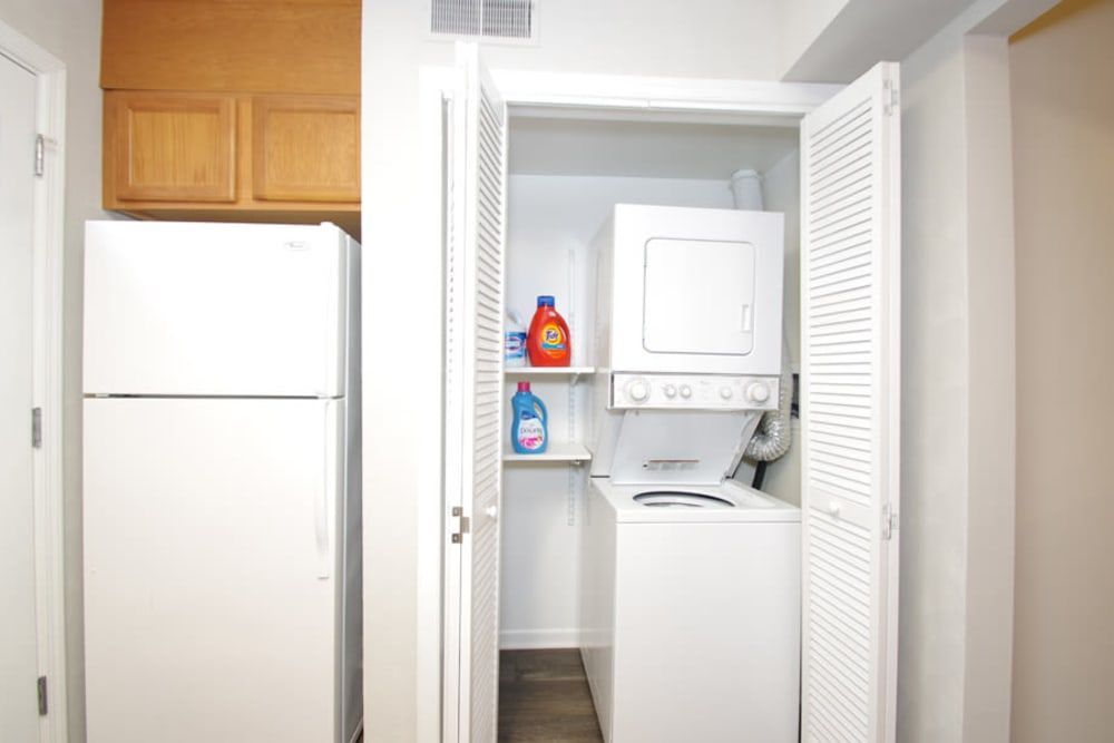 A laundry room with a washer and dryer and a refrigerator at Old Mill Townhomes in Lynchburg, VA.